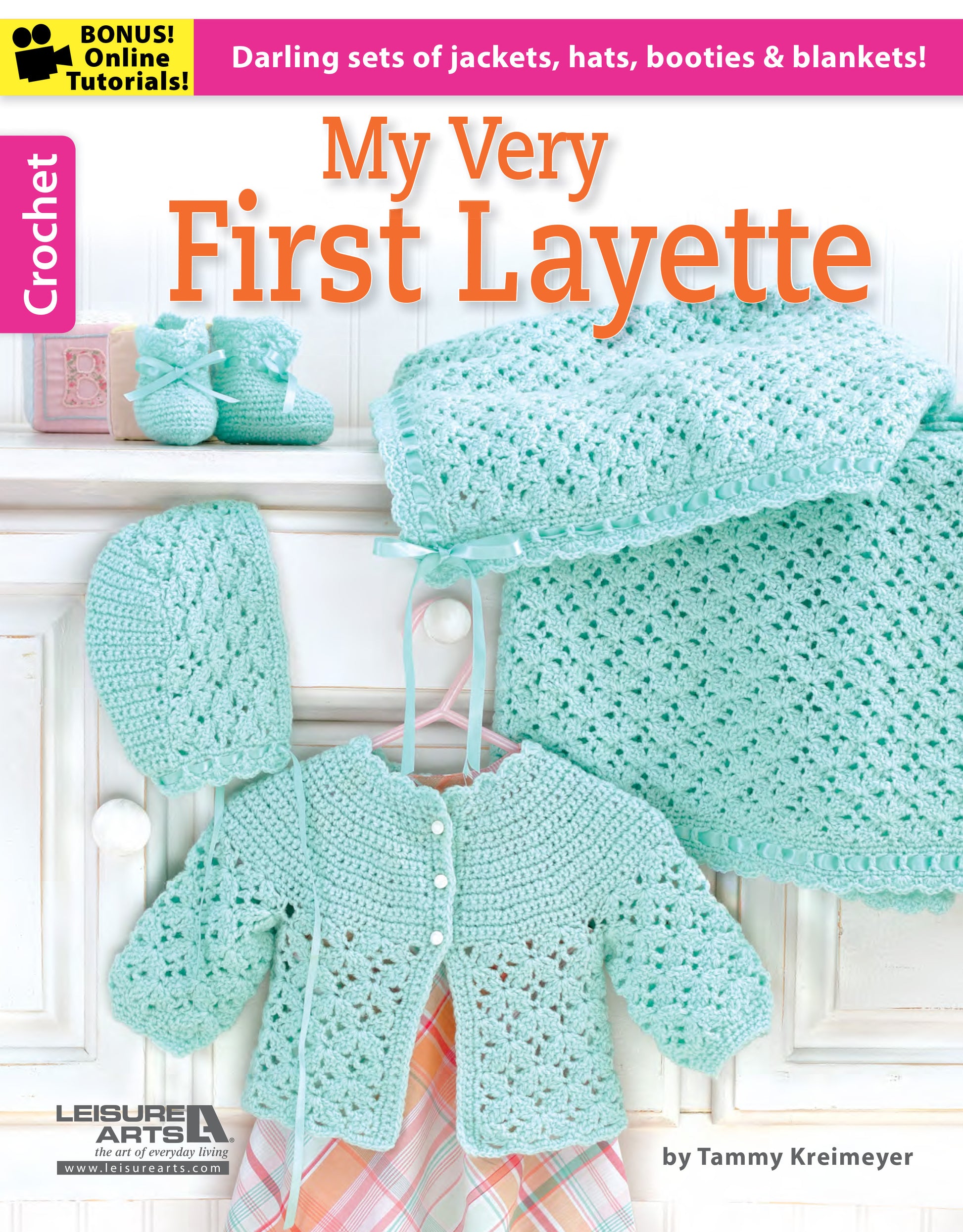 The cover of "My Very First Layette 2" by Leisure Arts displays pastel green crochet baby items—bonnet, sweater, booties, and blanket—highlighting simple projects for cute baby sets. Includes online tutorial info and a soft pastel design.