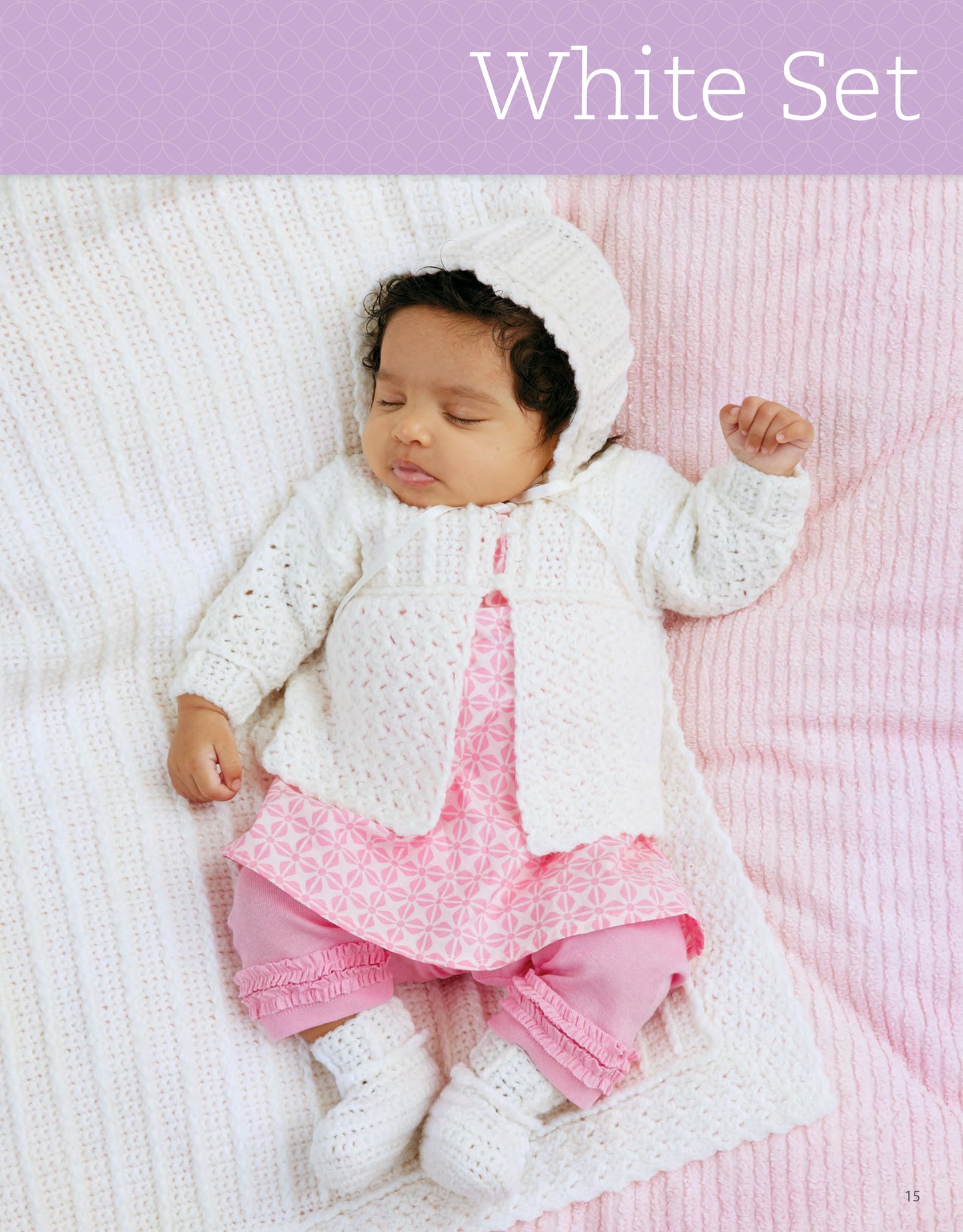 A baby in a white knitted bonnet, sweater, and booties over a pink outfit rests on a white and pink blanket. Text reads: My Very First Layette 2 by Leisure Arts—perfect inspiration for easy baby crochet projects.