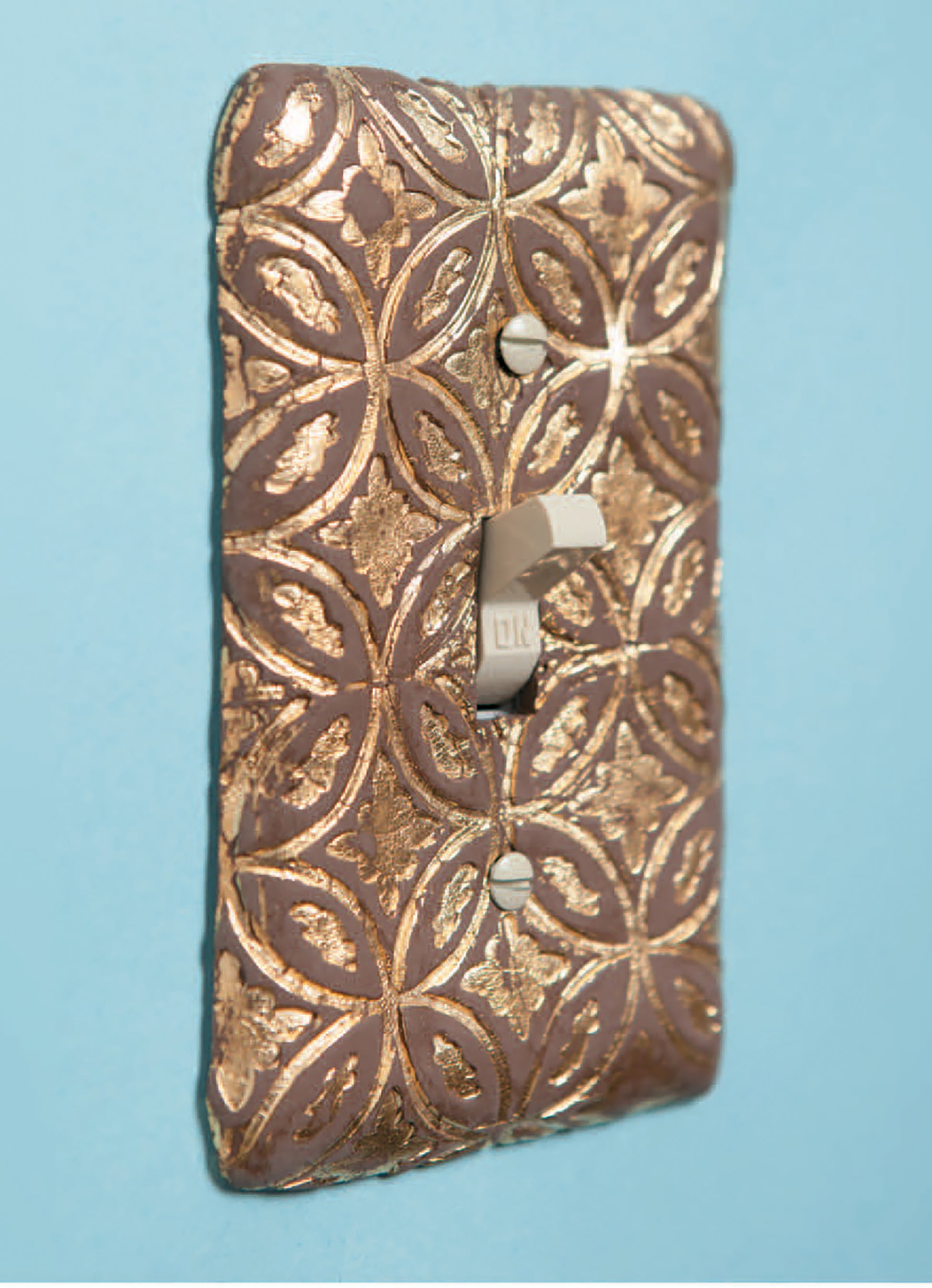 Get inspired for polymer clay projects with "Clay Creations for All" by Leisure Arts—perfect for beginner crafting, like making metallic light switch covers with raised gold geometric and floral patterns.