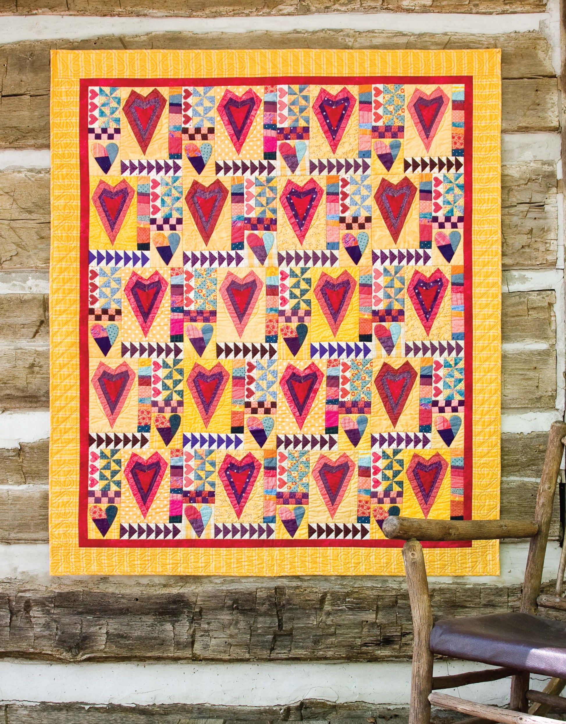 The Leisure Arts Lap & Throw Quilts features a vibrant patchwork design with heart blocks, flying geese rows, and pinwheels on yellow—an inspiring all-occasion quilt perfect for display or use in any cozy space.