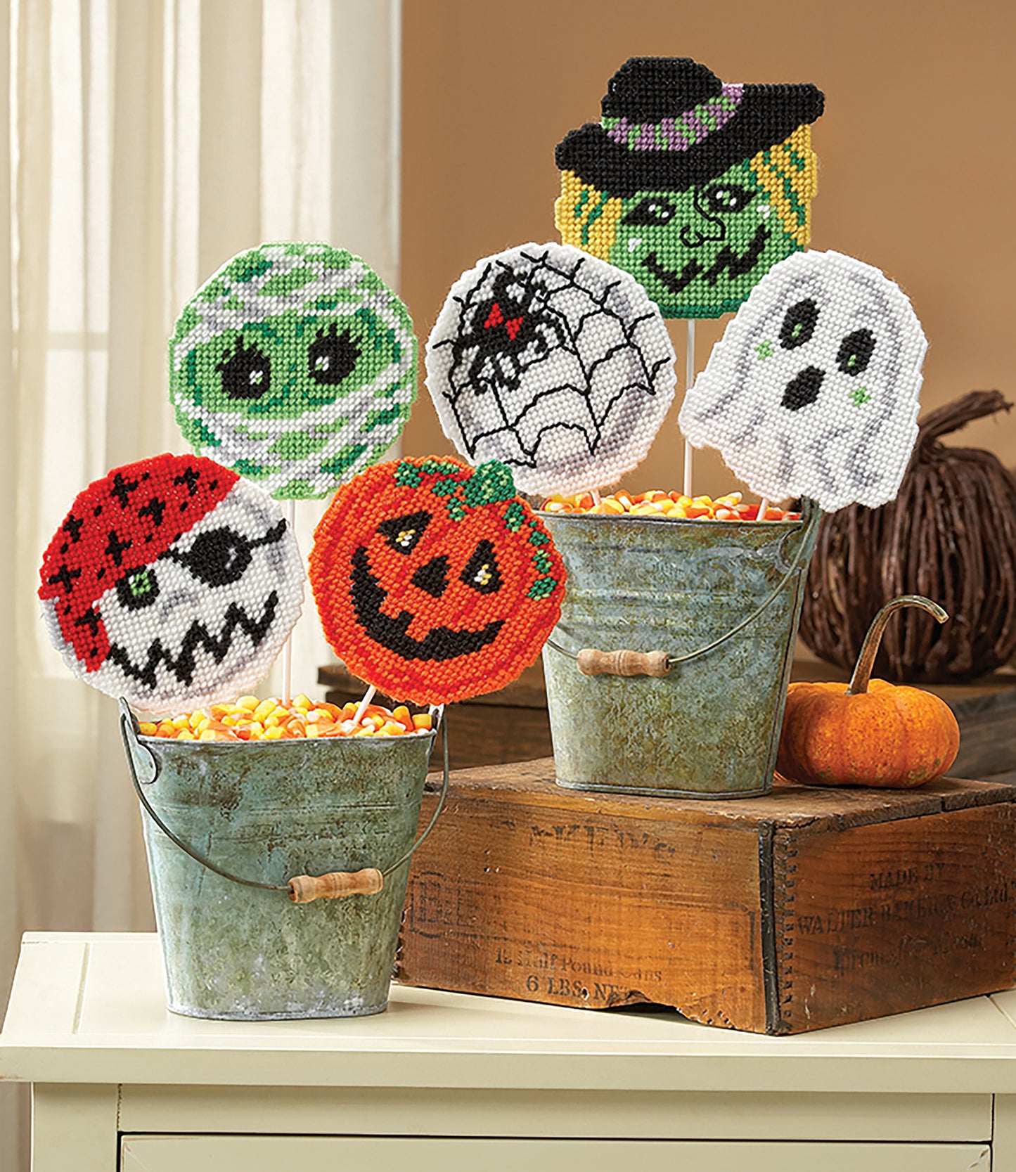 Six beaded Halloween coasters and lollipop covers by Leisure Arts—mummy, witch, spider web, ghost, skull, and pumpkin—make festive holiday motifs or playful gift accents.