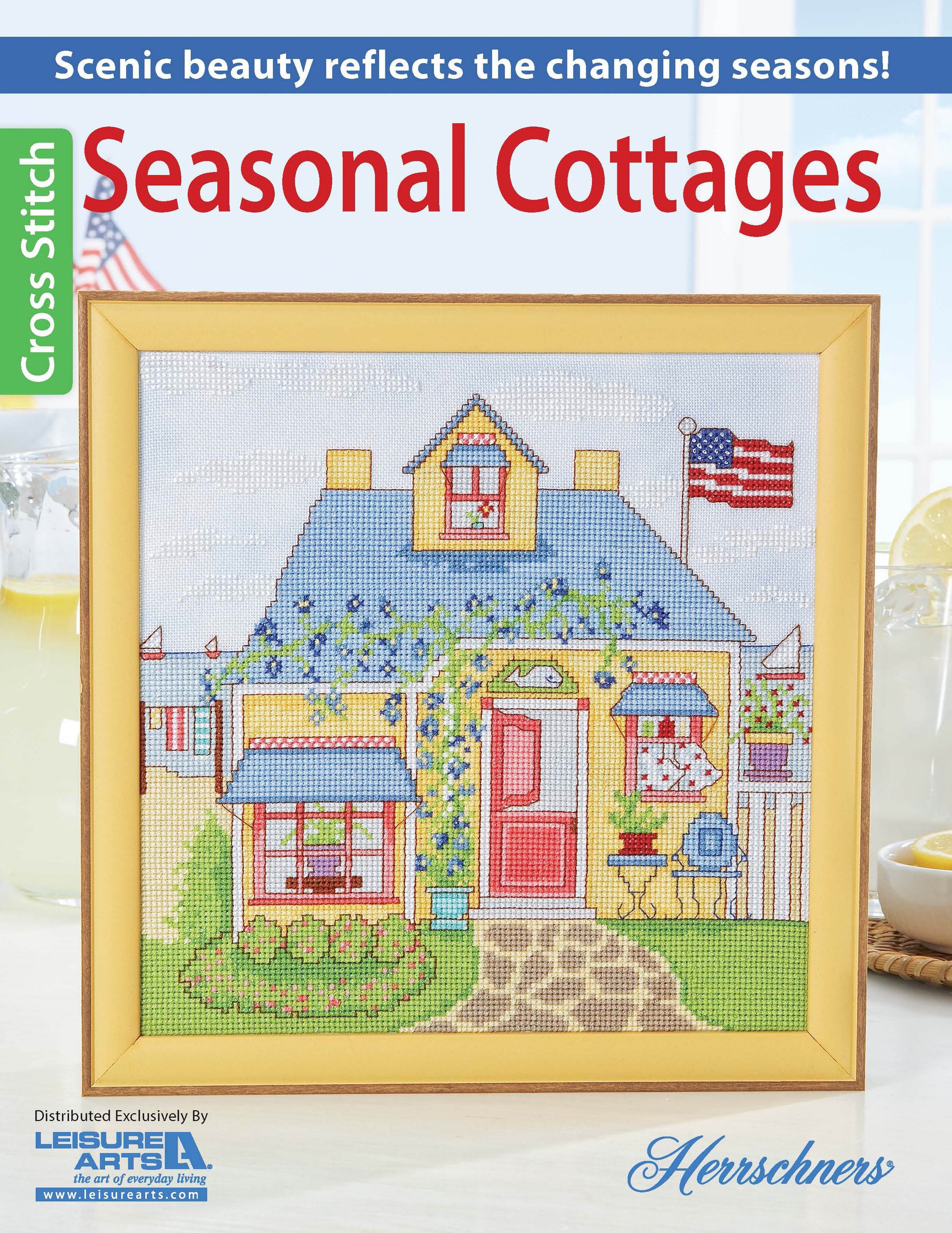 The Leisure Arts "Seasonal Cottages Cross Stitch" features a framed design of a cottage with flowers, picket fence, and U.S. flag on hand-dyed fabric, highlighted on the magazine cover.