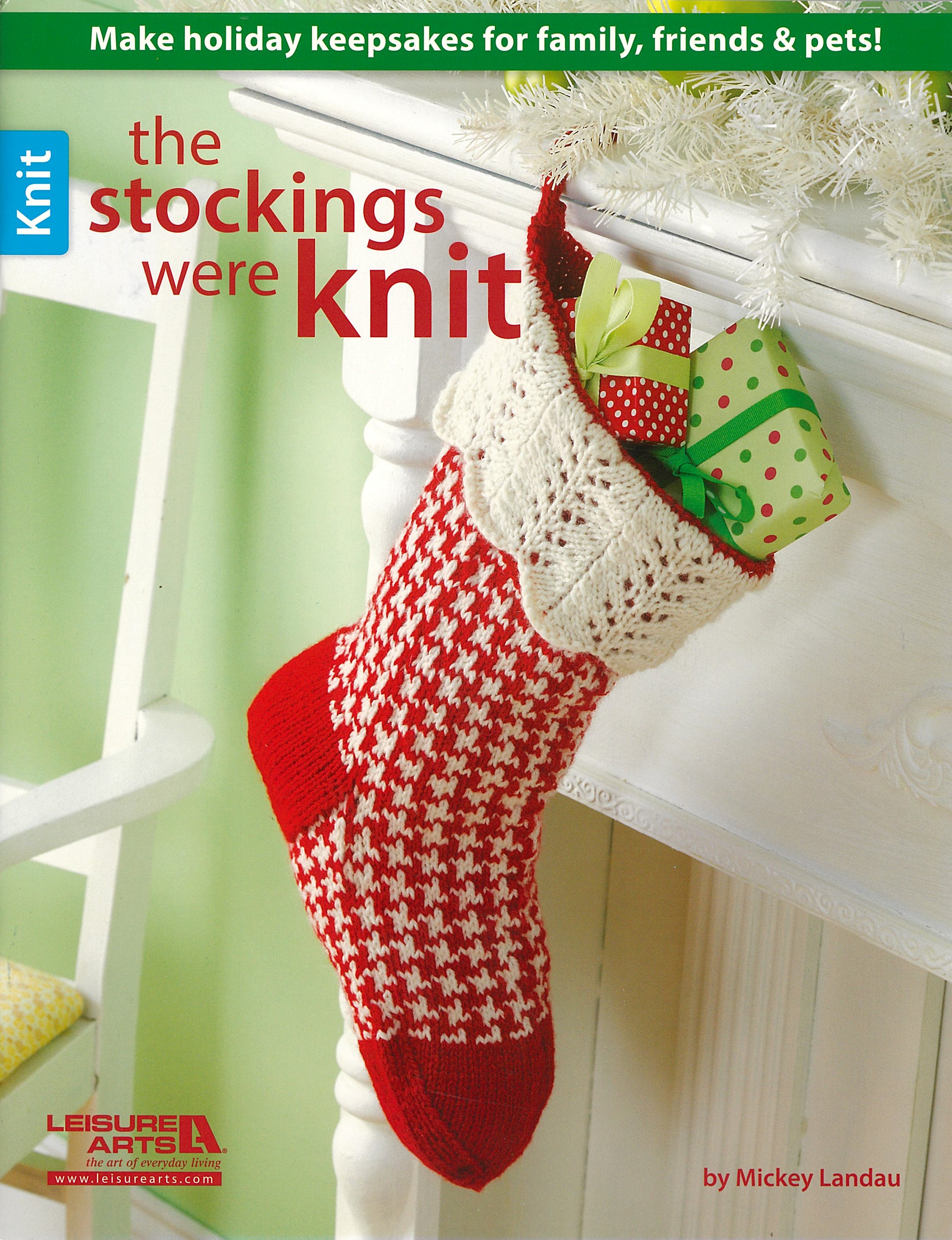 A Christmas stocking filled with gifts hangs on a mantel beside the magazine "The Stockings Were Knit" by Leisure Arts, featuring ideas for making holiday keepsakes for family, friends, and pets.