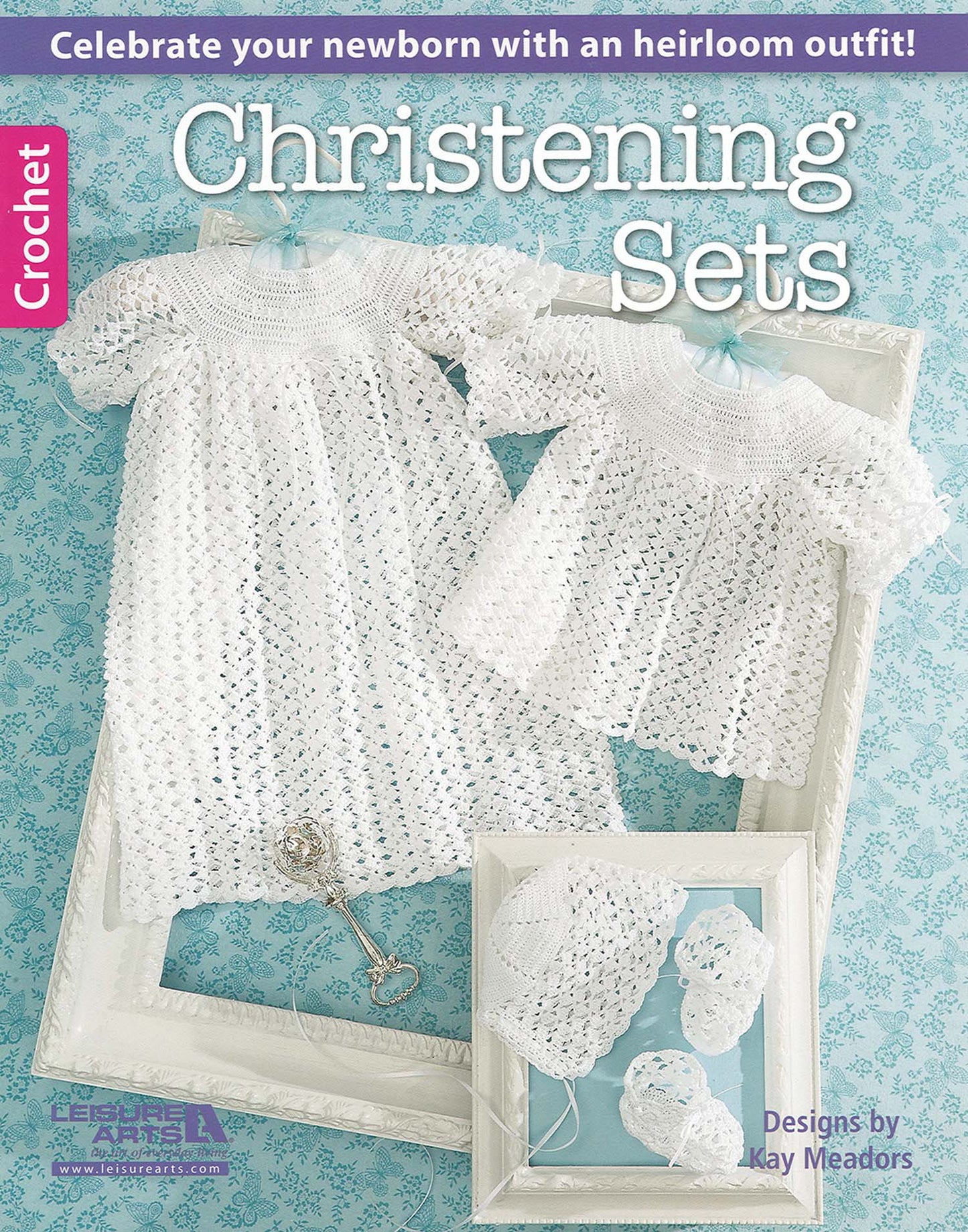 Cover of “Christening Sets—Celebrate Your Newborn With an Heirloom Outfit!” by Leisure Arts shows two lacy white baby dresses, bonnet, and booties in white frames on blue. Features timeless crochet christening outfit patterns for newborns.