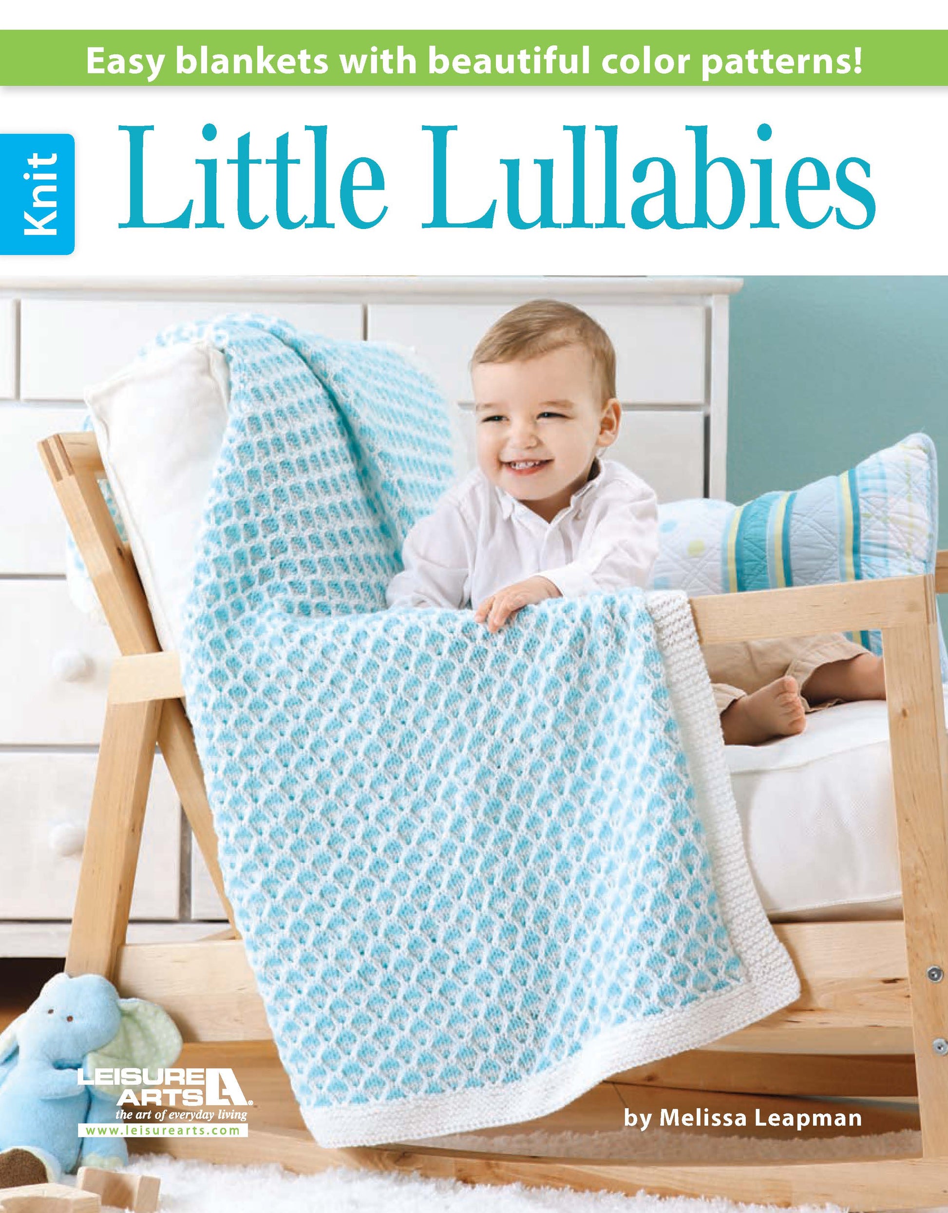 A smiling baby sits in a wooden crib with a blue and white knit blanket. Stuffed toys and another blanket are nearby. This is the cover of Leisure Arts' Little Lullabies—5 Knit Baby Afghans, featuring beginner patterns for handmade baby gifts.