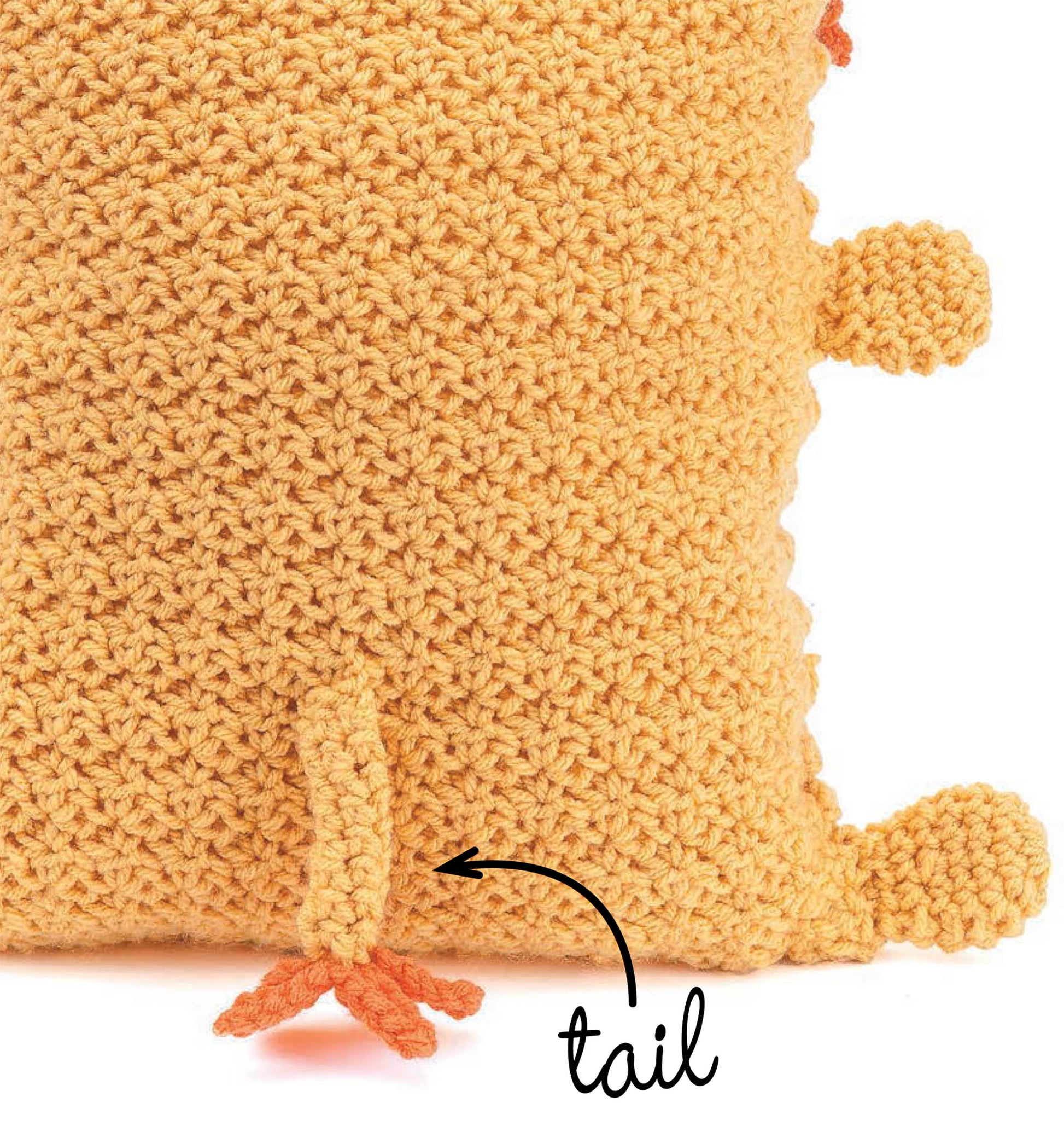 Close-up of a textured, orange Kids Animal Pillow by Leisure Arts, featuring small round bumps and an attached tail labeled "tail." Ideal as decorative accessories for kids or fans of beginner crochet patterns.