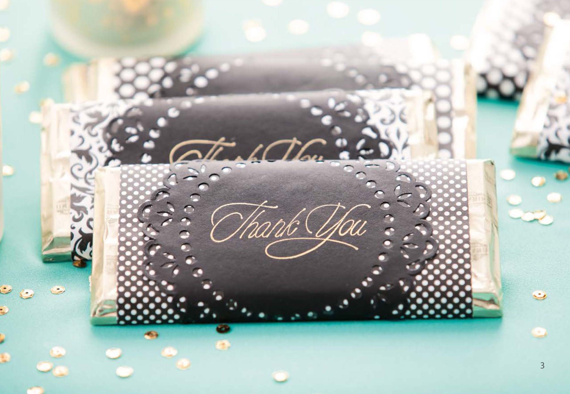 The Glam Wedding Favors Digital Download by Leisure Arts features chocolate bar wrappers in elegant black and white with gold “Thank You” text, ideal for wedding favors and display among gold and white confetti.