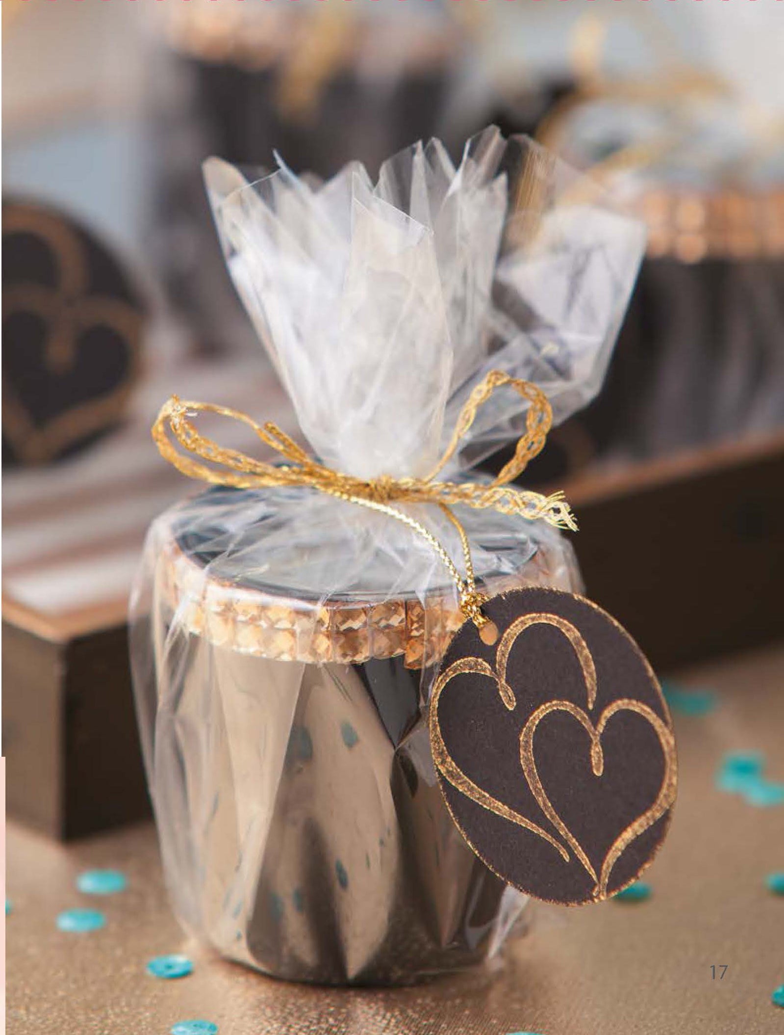 Glam Wedding Favors Digital Download by Leisure Arts: Small jar design wrapped in clear cellophane, tied with gold ribbon, and black tag with gold-outlined hearts—ideal for affordable gifts or wedding favors. Background shows similar jars on a wooden tray.