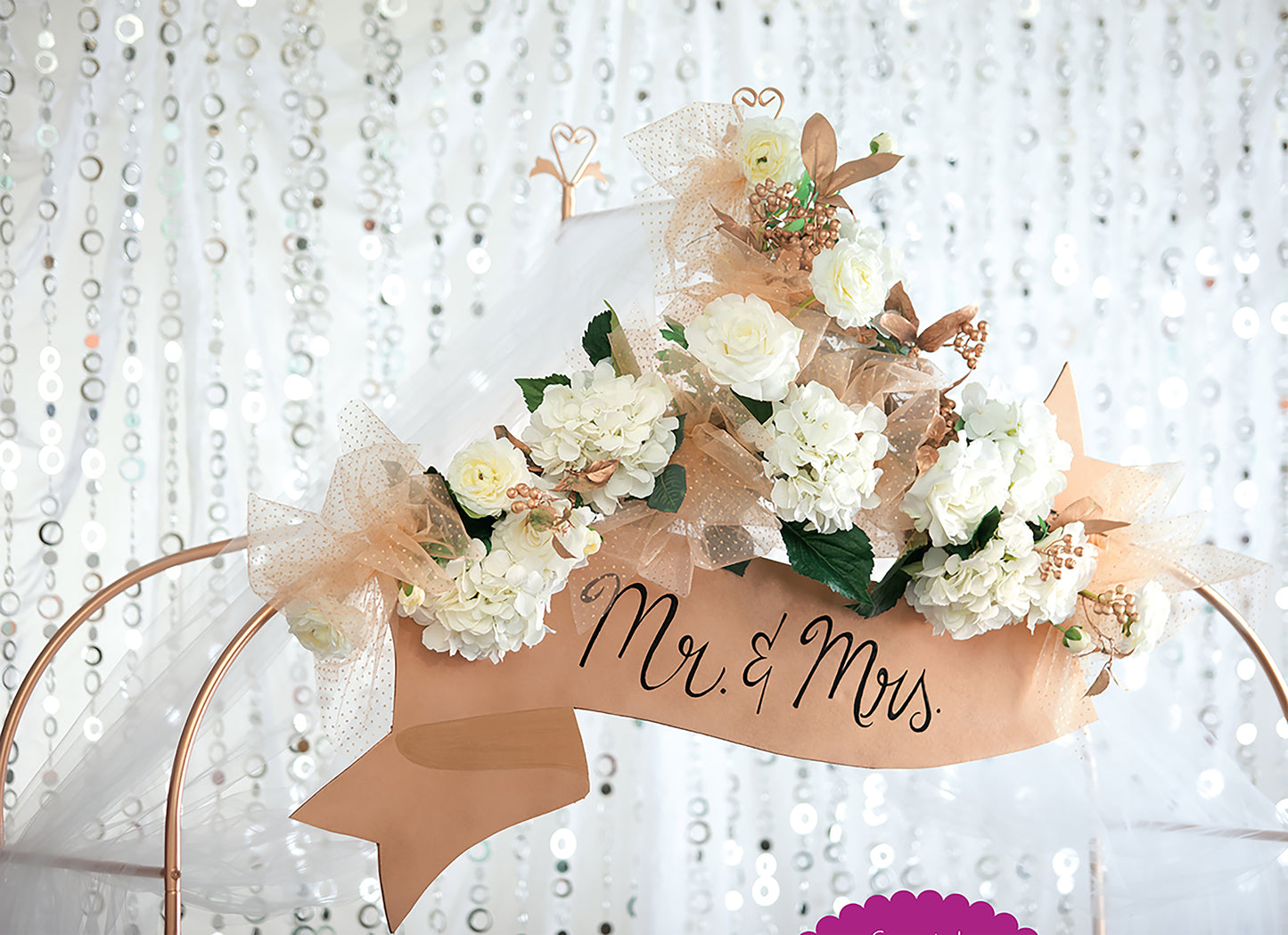 Glam Wedding Florals by Leisure Arts features white roses, hydrangeas, gold mesh ribbons, and a "Mr. & Mrs." banner on a sequin backdrop—ideal for DIY wedding decor or beginners learning floral arrangement basics.