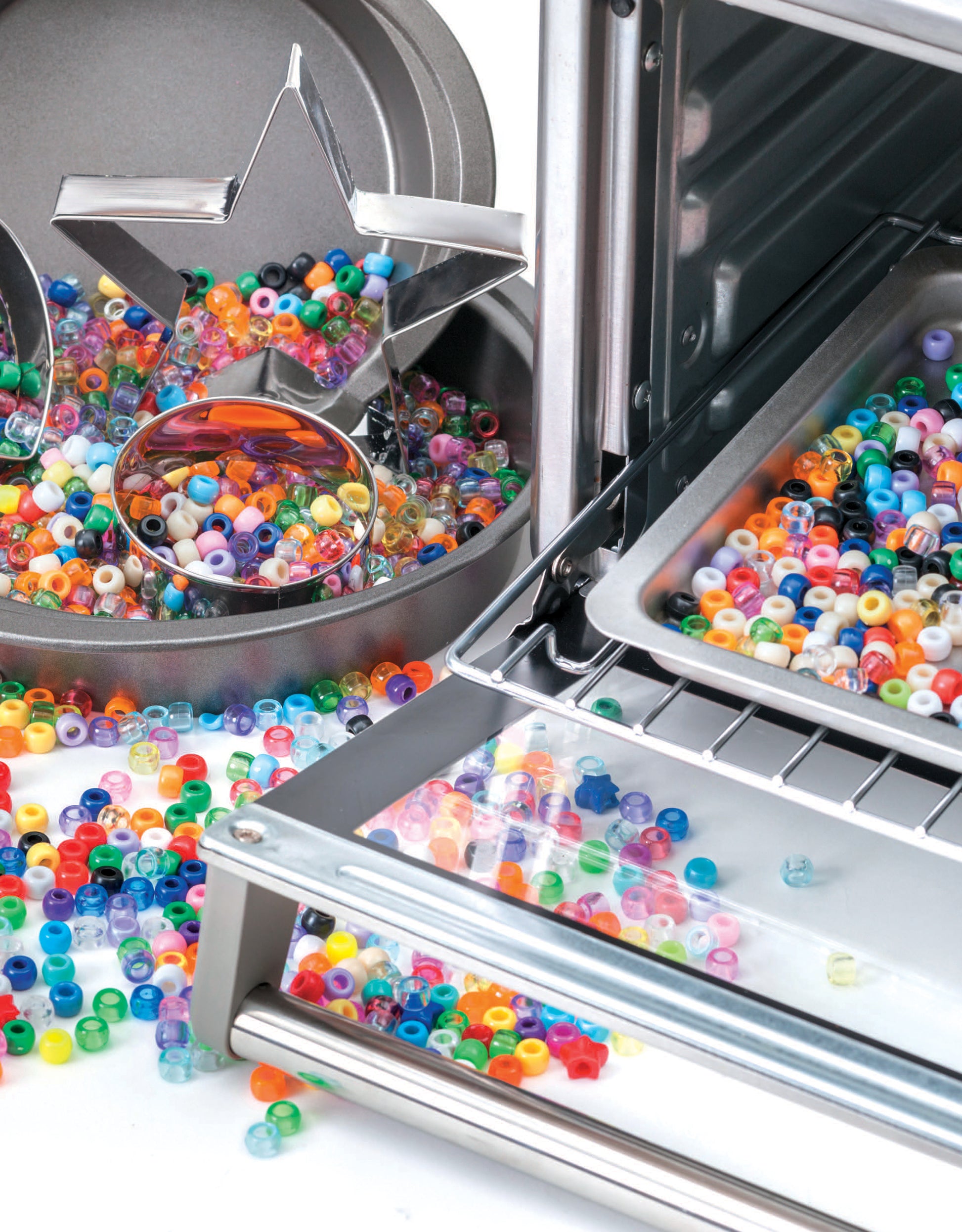 Leisure Arts’ Melted Pony Bead Art kit features colorful plastic beads in a baking pan with star and circle cookie cutters—ideal for beginner crafts like melted bead projects or making vibrant suncatchers near the oven.