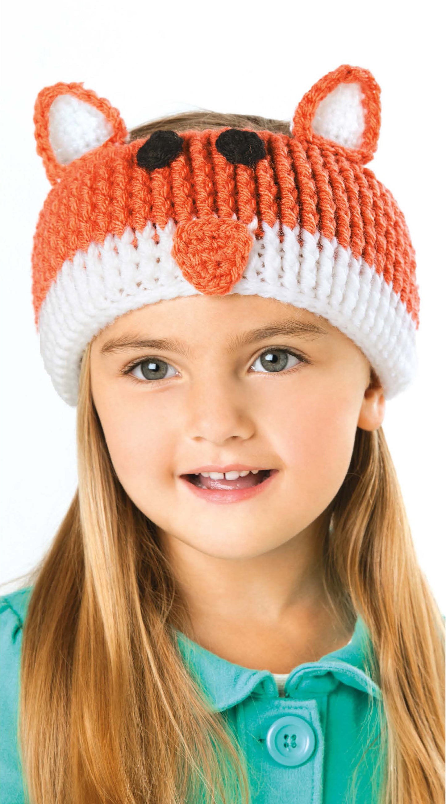 A young girl in a teal top smiles slightly while wearing Leisure Arts' Little Animals Headgear—a cute crochet beanie styled as a fox with orange and white ear warmers and nose.