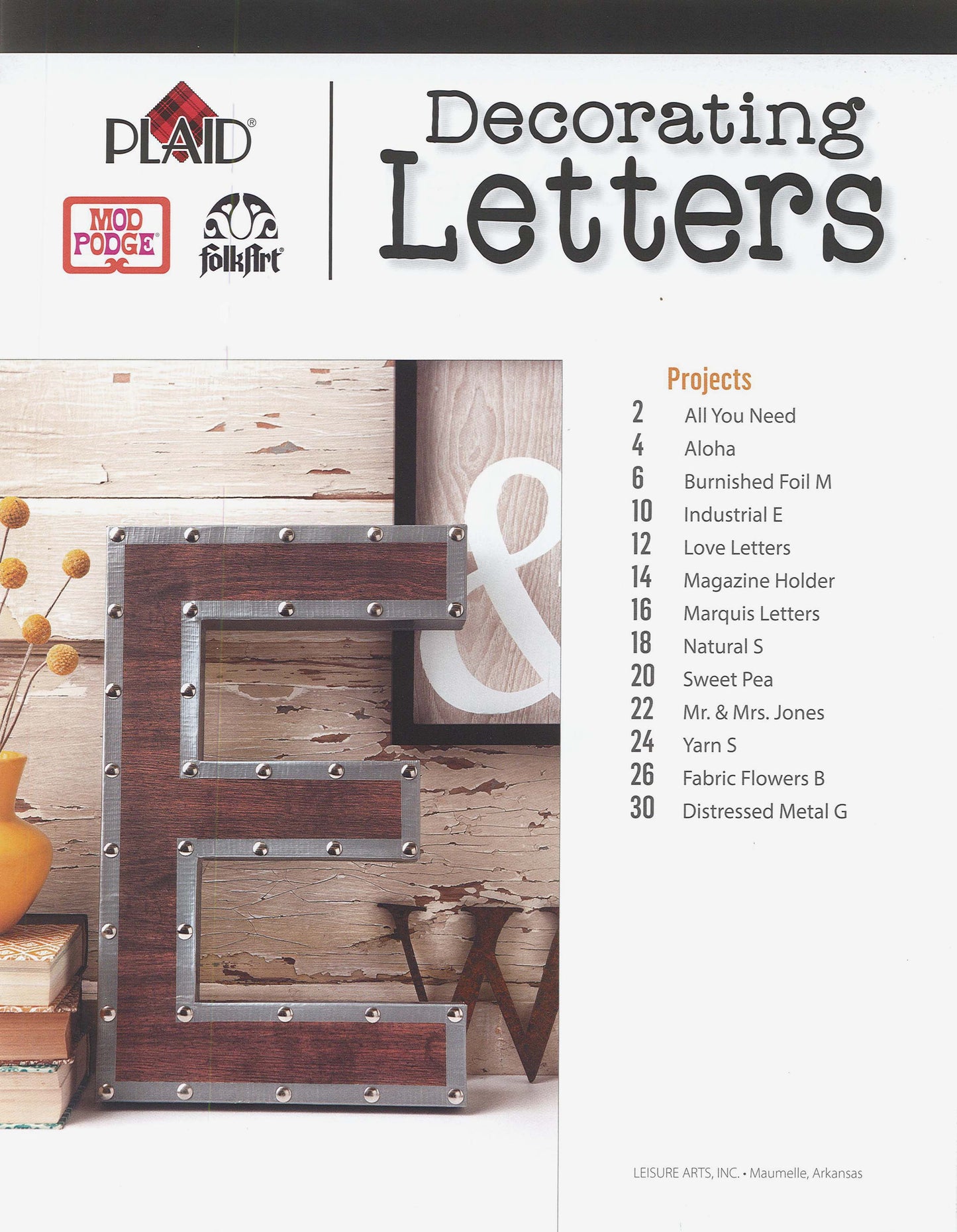 Cover of the Decorating Letters Digital Download by Leisure Arts, featuring a large wooden letter E with metal accents, styled on a shelf with small decor items and Mod Podge letters, plus Leisure Arts branding.