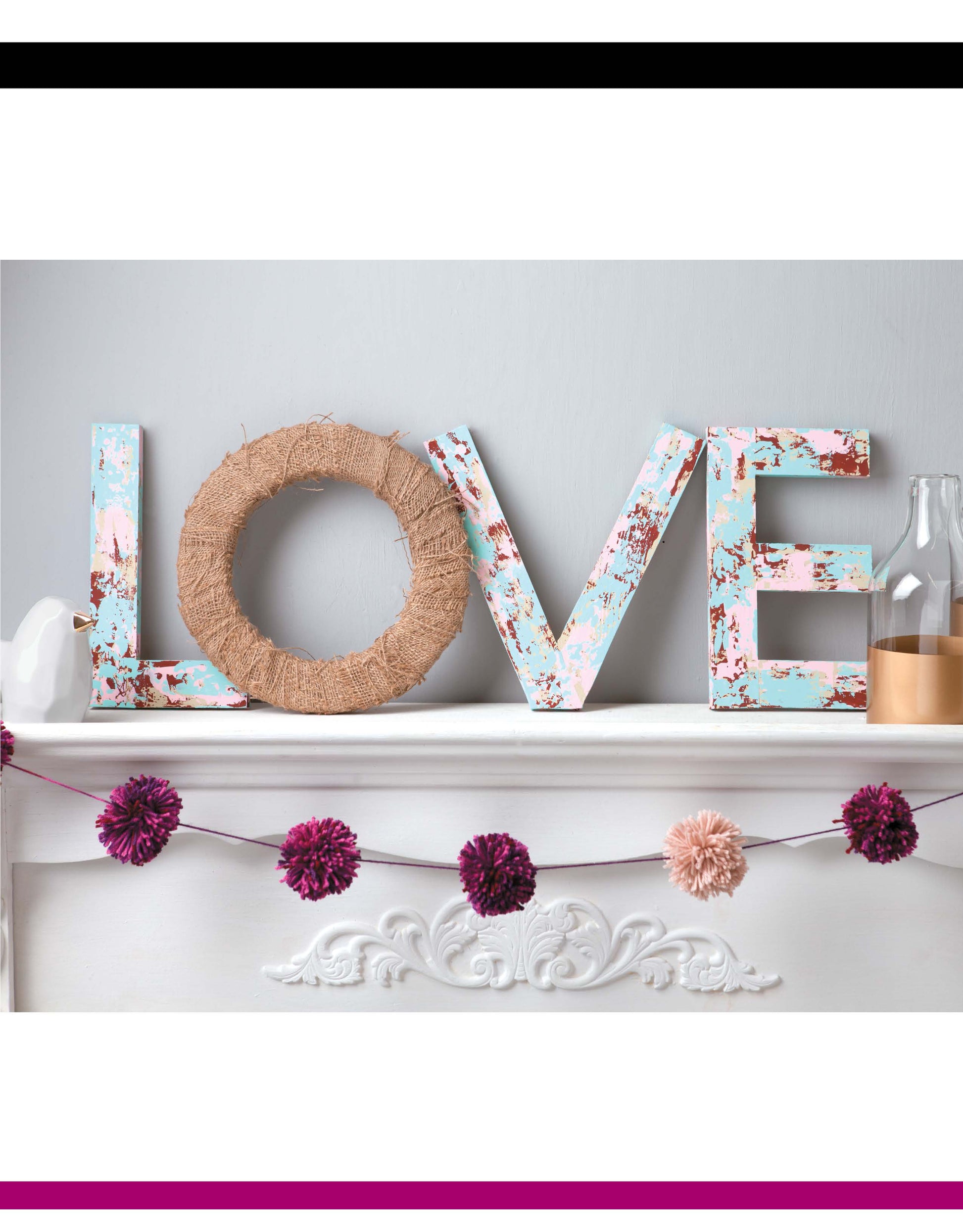 Decorating Letters Digital Download by Leisure Arts spells LOVE on a white mantel. The L, V, and E feature pastel florals; the O is wrapped in twine. Pink and purple pom-pom garland and bottles complete this charming home decor look.