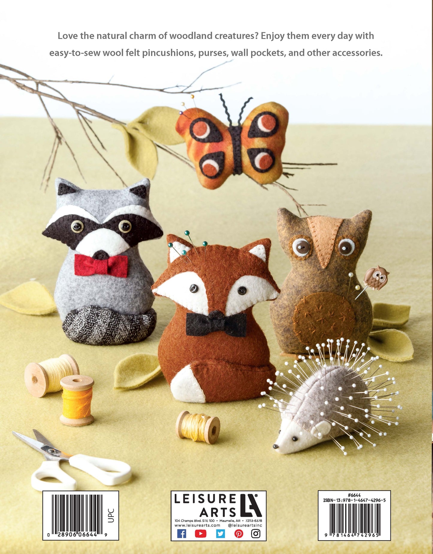 Four easy-to-sew felt critters—a raccoon, butterfly, owl, fox—and a wool felt hedgehog pincushion from Leisure Arts' "Felt Crafty Critters Digital Download" sit on green felt with sewing supplies; guides and publisher info frame the scene.