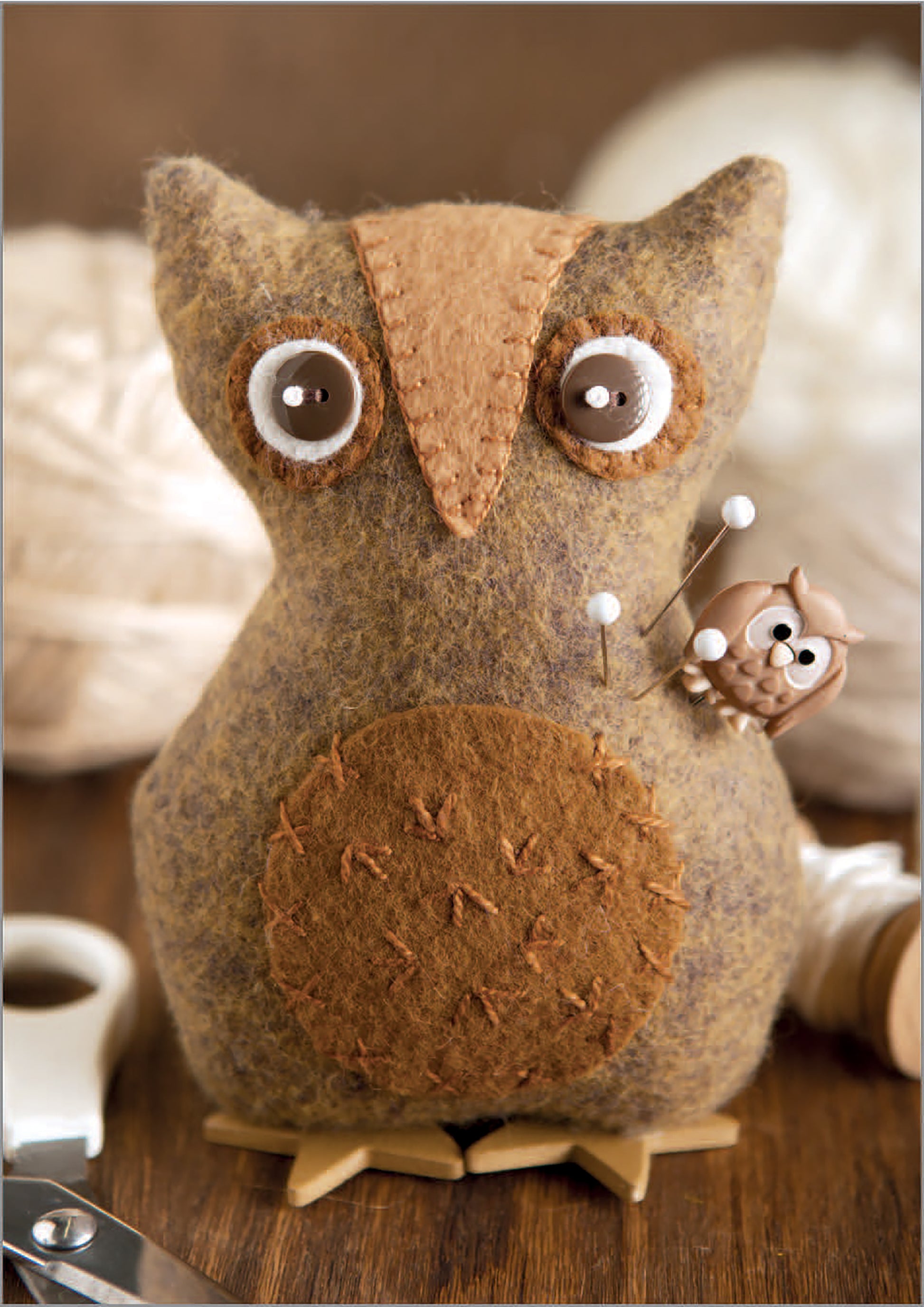 The Felt Crafty Critters Digital Download by Leisure Arts features a handmade felt owl pincushion with button eyes and stitched accents, perfect for holding pins. It’s easy to sew and ideal for creative craft sessions.