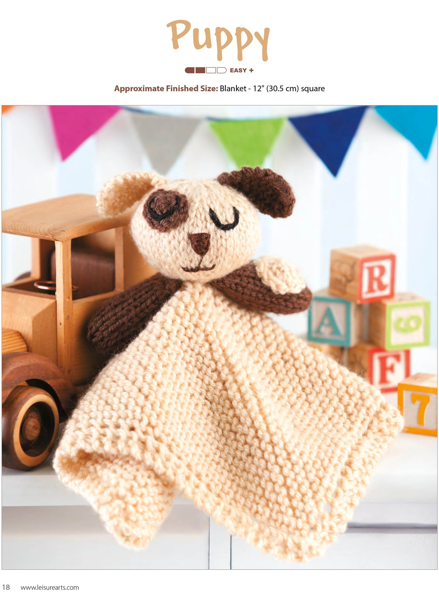 The Leisure Arts Animal Lovies—Huggable Blanket Buddies Make Adorable Gifts! features a knitted cream and brown puppy lovey with a blanket body and plush puppy head, shown beside a wooden toy truck, ABC blocks, and pennant banners. Bonus! Online tutorials included.