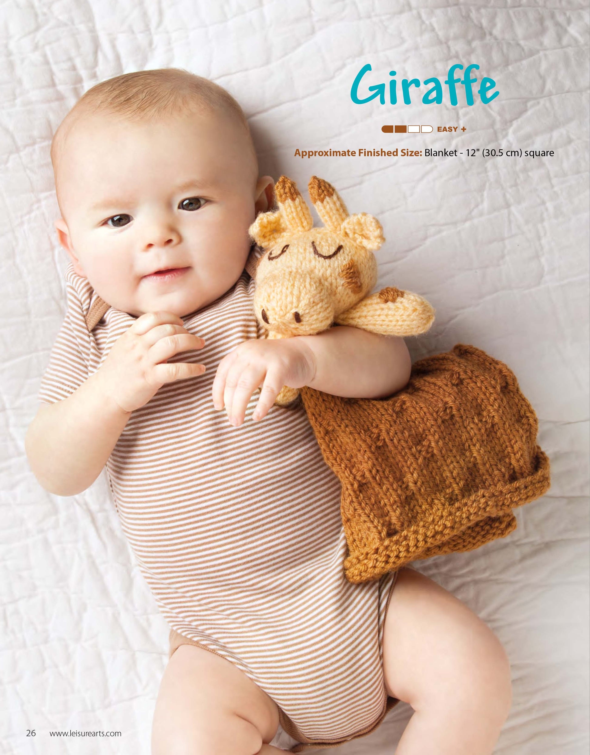 A baby in a striped onesie lies on a white quilt, holding an Animal Lovies—Huggable Blanket Buddy by Leisure Arts. The image features this adorable knit gift with beginner patterns and bonus online tutorials.