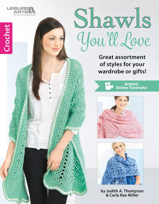 The cover of Crochet Shawls You'll Love by Leisure Arts displays a woman in a mint green shawl, with photos of pink and blue versions, highlighting beautiful crochet shawl patterns and step-by-step instructions.