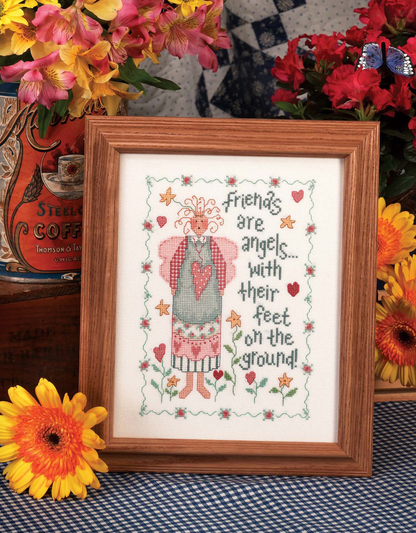 The Leisure Arts Loving Hearts Cross Stitch features a whimsical angel, flowers, and hearts with the saying “Friends are angels...with their feet on the ground!” Framed and vibrant, it’s ideal for charming home decor.