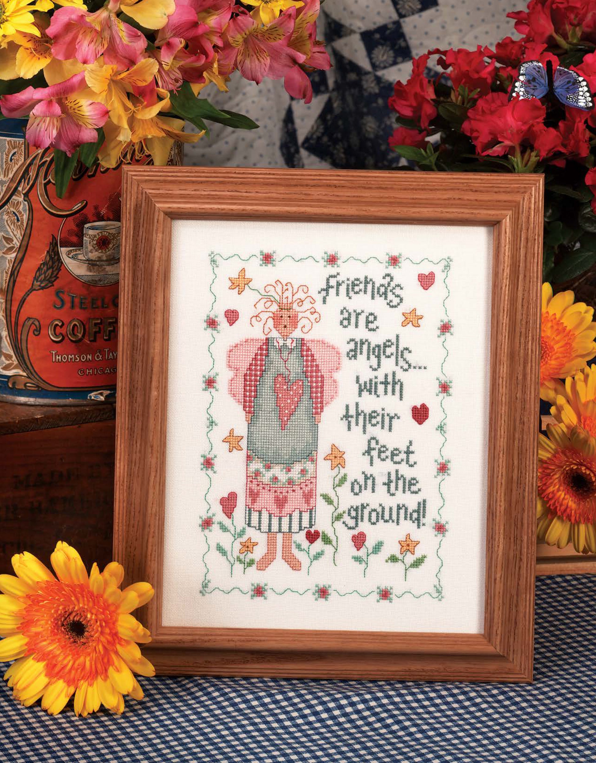 The Leisure Arts Loving Hearts Cross Stitch features a whimsical angel, flowers, and hearts with the saying “Friends are angels...with their feet on the ground!” Framed and vibrant, it’s ideal for charming home decor.