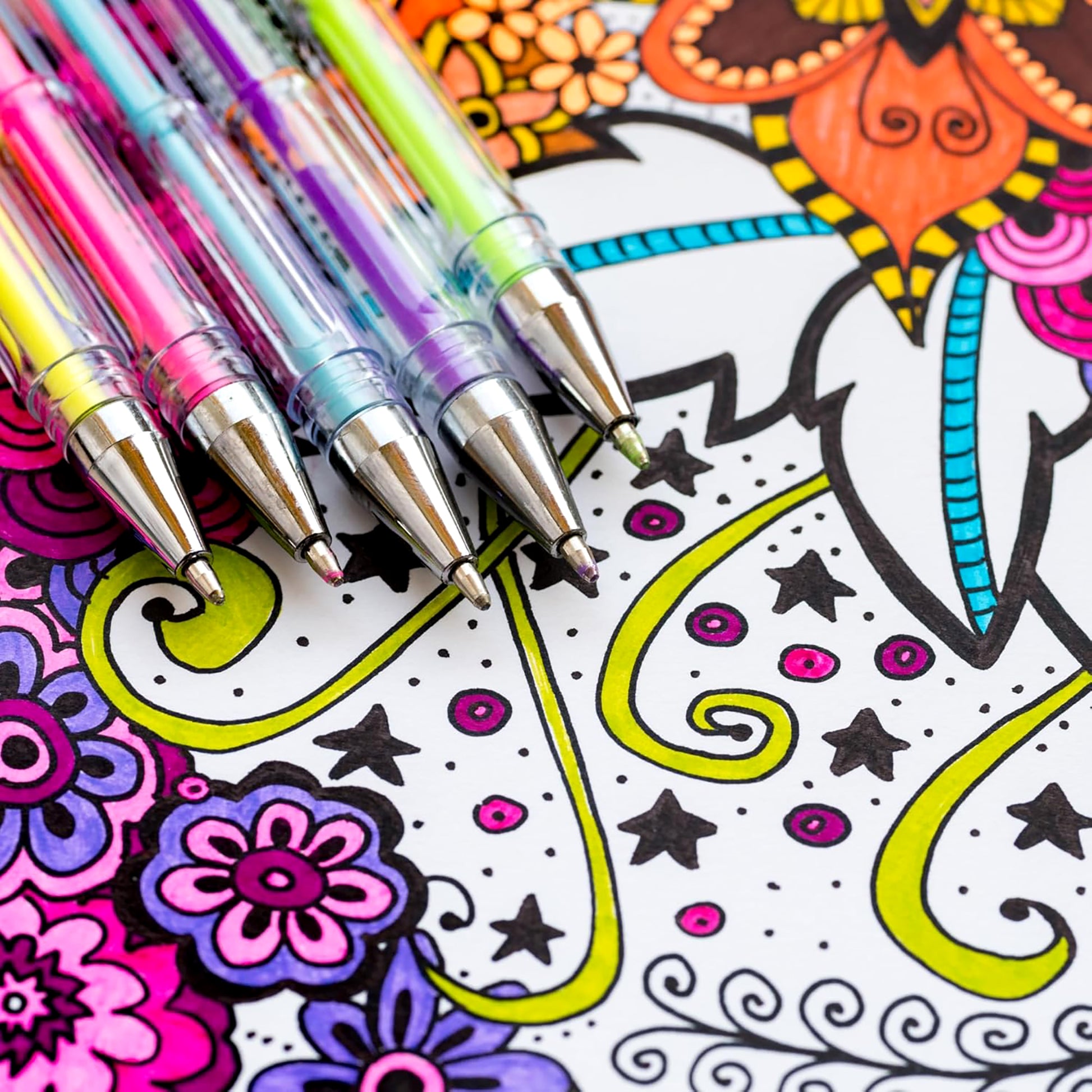 Four colorful gel pens rest on an intricate, partially colored page from "The Best of Color Art for Everyone" by Leisure Arts, featuring bright pinks, purples, greens, and oranges—perfect for stress relief with over 90 designs to enjoy.