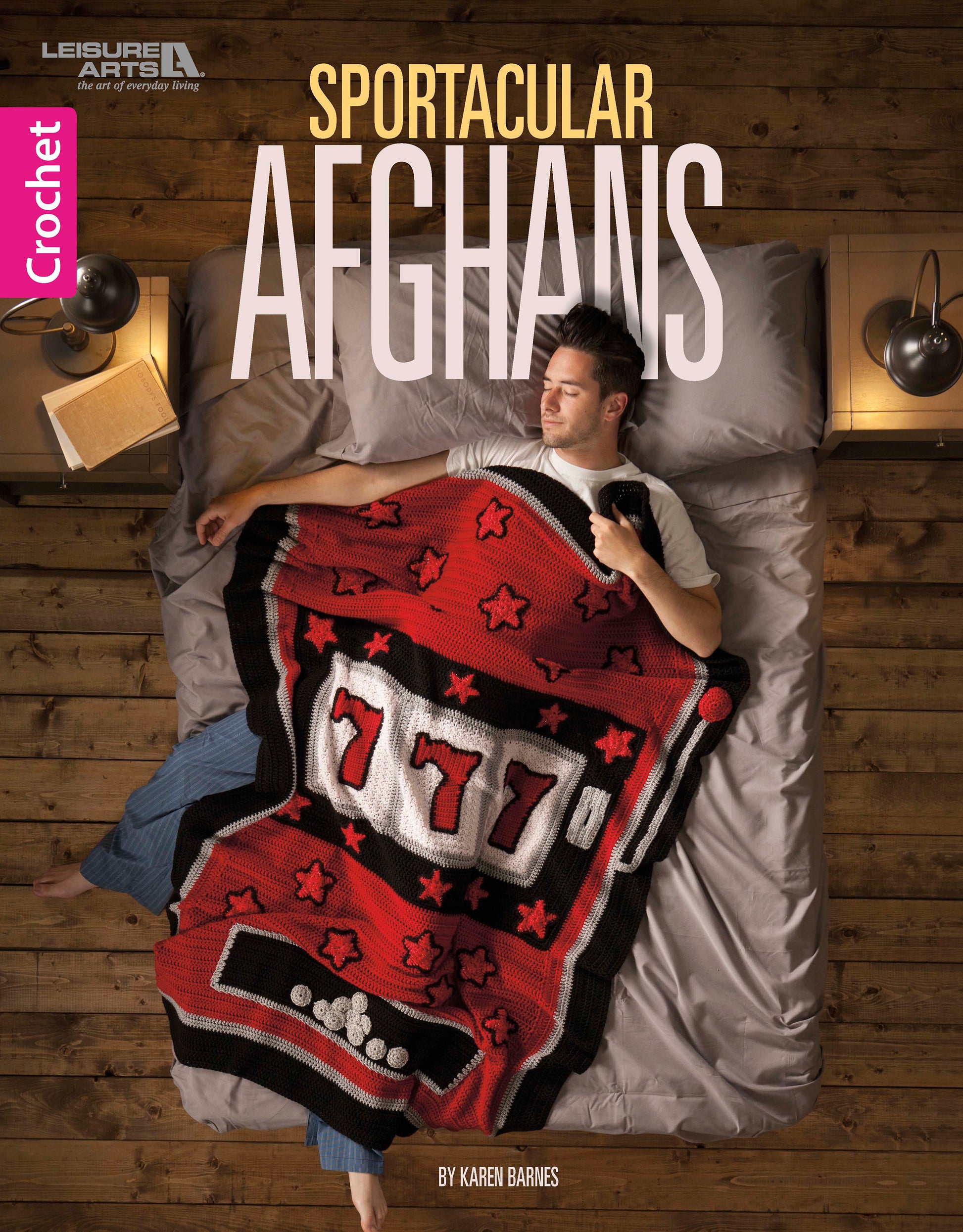 A man relaxes in bed under a red slot machine-themed crocheted blanket, a playful sports afghan design from the Sportacular Afghans to Crochet Digital Download by Leisure Arts—fun décor for any man cave.