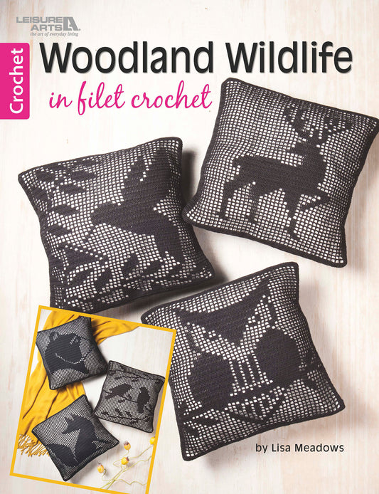 Three dark pillows with deer, butterfly, and rabbit woodland designs are displayed on a light surface. “Woodland Wildlife in Filet Crochet” by Leisure Arts features elegant lace crochet pillow patterns by Lisa Meadows.