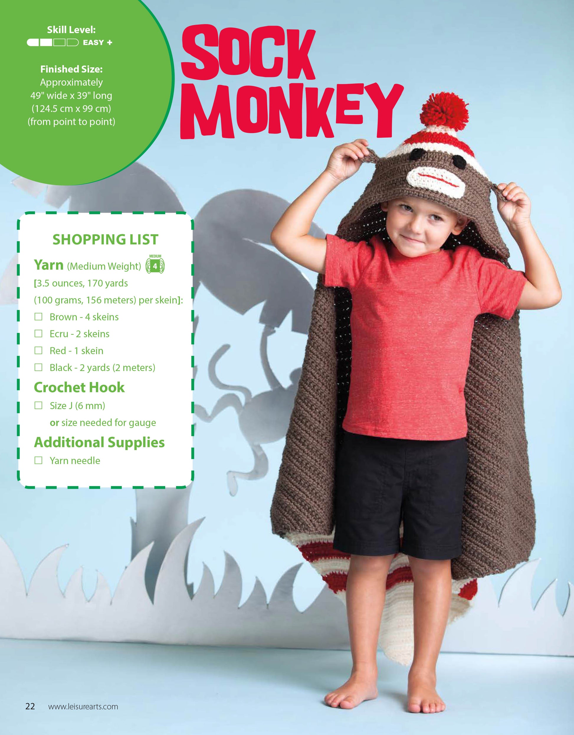 A young boy smiles inside a Leisure Arts Crochet Animal Blanket, made with medium weight yarn and playful appliqué. Cartoon jungle plants decorate the background, while text provides project details and a shopping list.