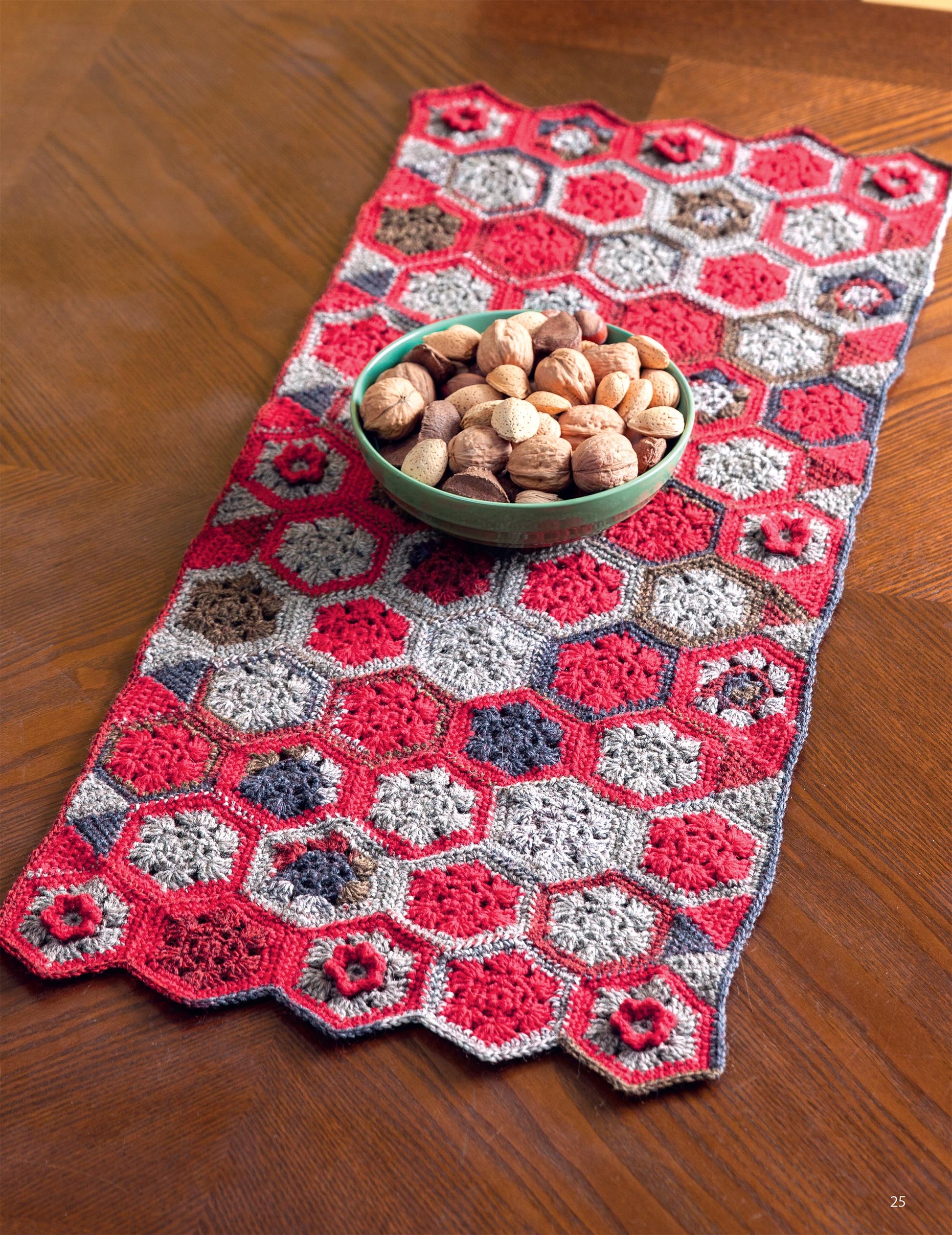 The Leisure Arts "Hooked On Quilted Crochet" digital download features beginner-friendly patterns like a scalloped-edge table runner with red, pink, grey, and maroon hexagons—perfect to brighten your home decor.