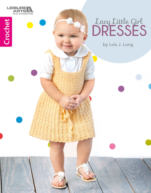 A toddler girl in a white shirt, yellow crochet dress, white sandals, and headband smiles before a polka dot backdrop. Text: Lacy Little Girl Dresses by Leisure Arts.