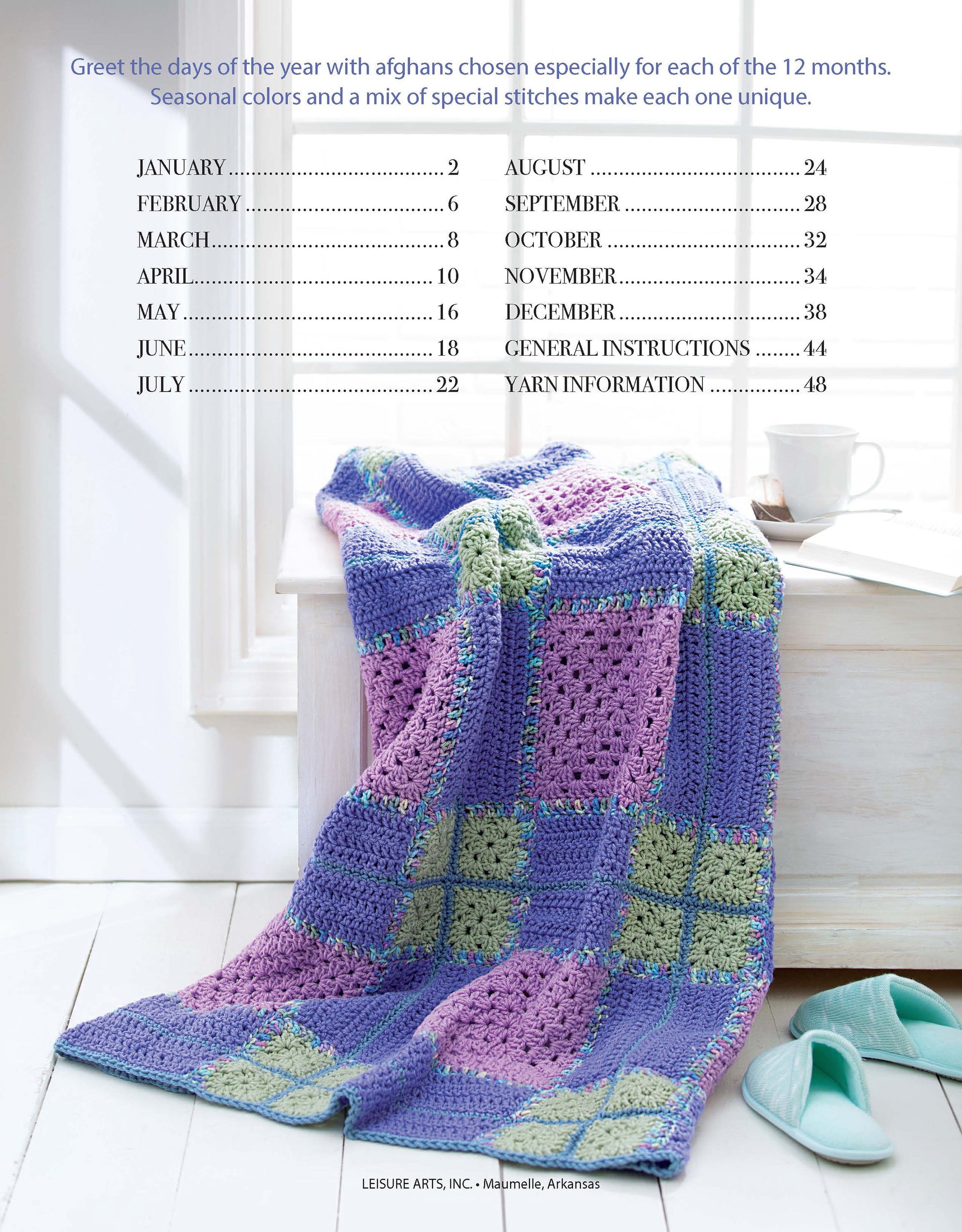 A colorful geometric afghan in purple, blue, and green rests on a white bench by a window. Above is a month-by-month index from "A Year of Afghans, Book 17 Digital Download" by Leisure Arts for medium weight yarn projects.