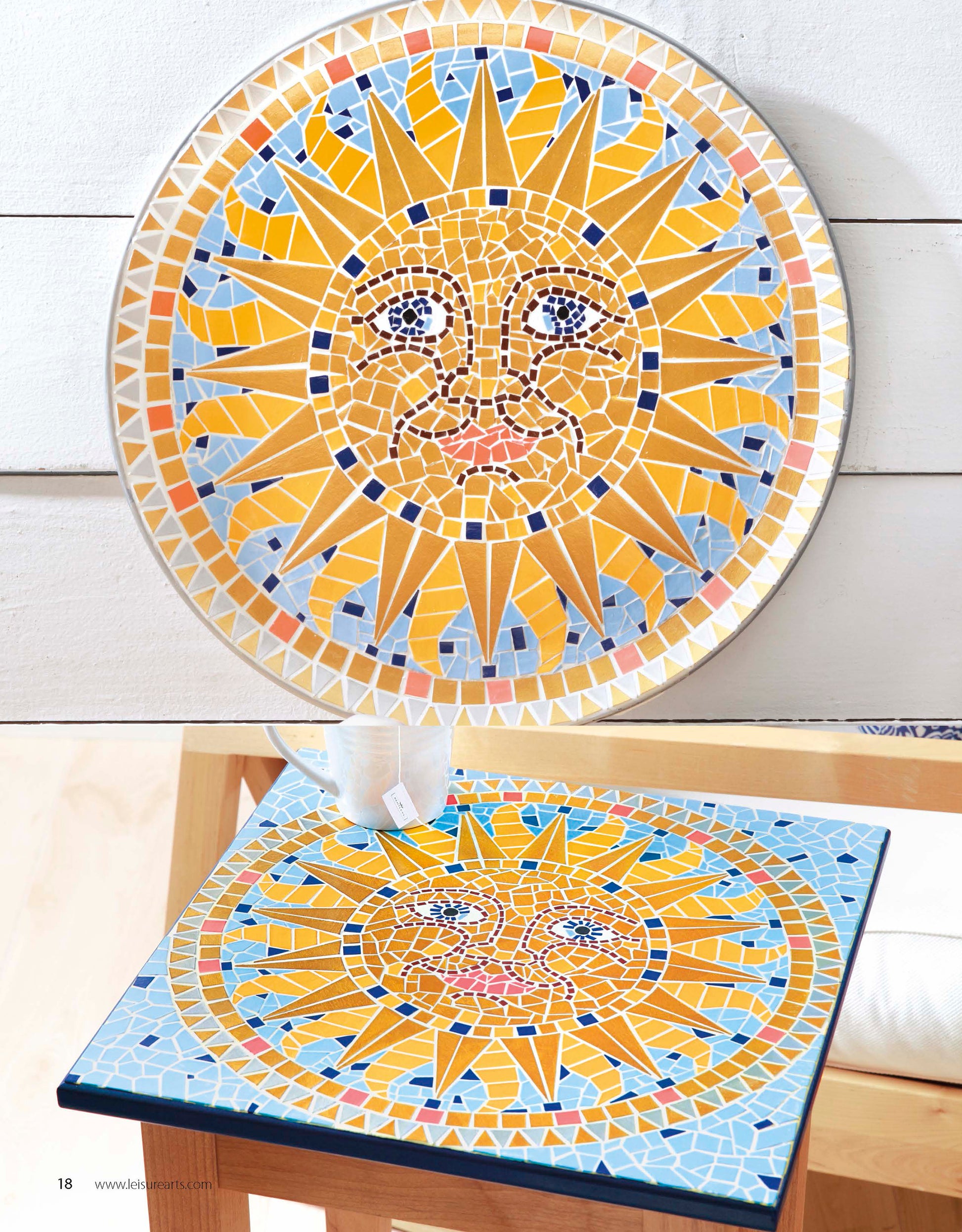 Create inviting home decor with two mosaic artworks inspired by the Beginner’s Guide to Faux Mosaics from Leisure Arts. Each piece features a vibrant yellow sun face set against a bold blue background, displaying expressive details and unique craft patterns. One is round and propped up, while the other is square and flat on a wooden stool—illustrating the versatility of free-form mosaic techniques taught in this guide.