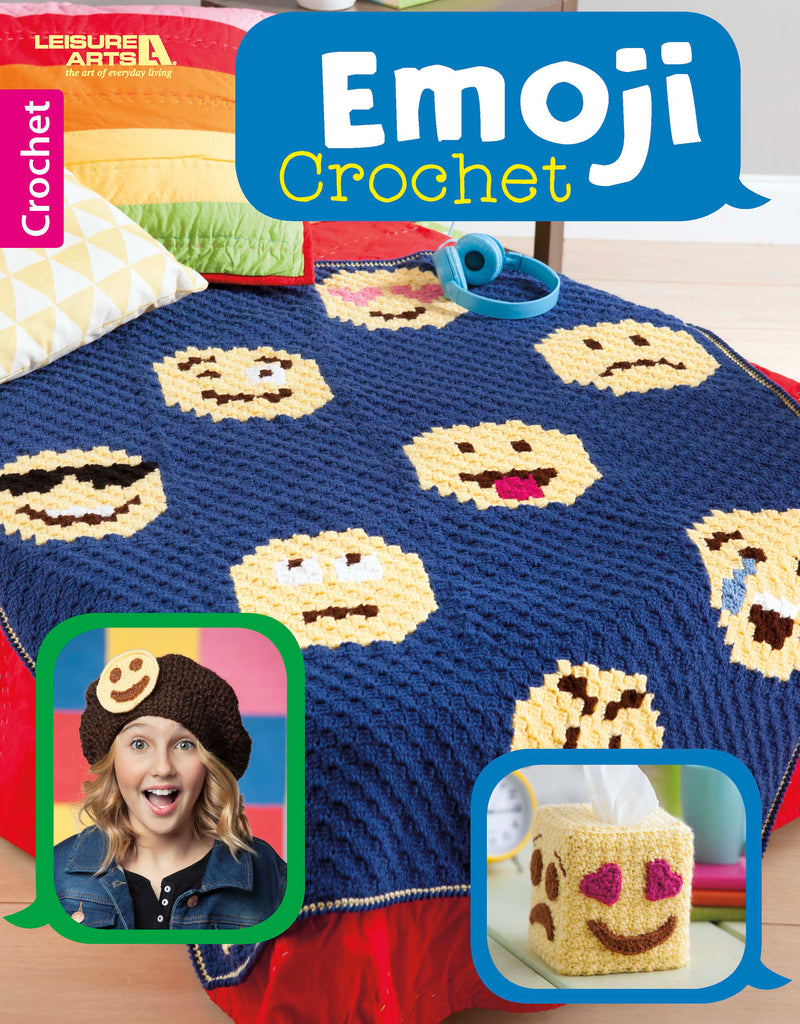 A blue blanket from Leisure Arts' Emoji Crochet, featuring yellow emoji faces and ideal for beginners, is displayed on a bed with colorful pillows, headphones, and a red cover. Insets show a girl in an emoji hat and an emoji tissue box cover.