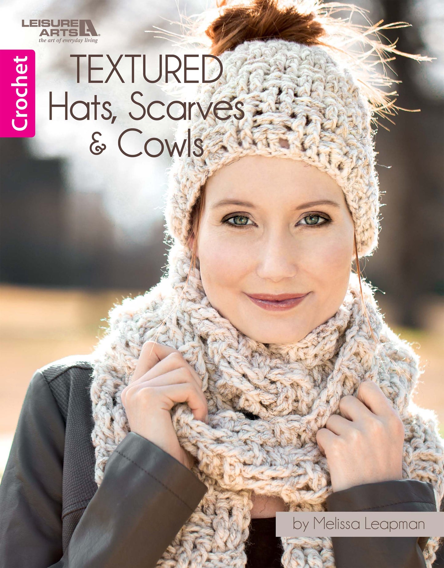 A woman wears a chunky crochet hat, scarf, and cowl outdoors on the cover of "Textured Hats, Scarves, & Cowls Digital Download" by Leisure Arts—the perfect guide for cozy crochet sets.