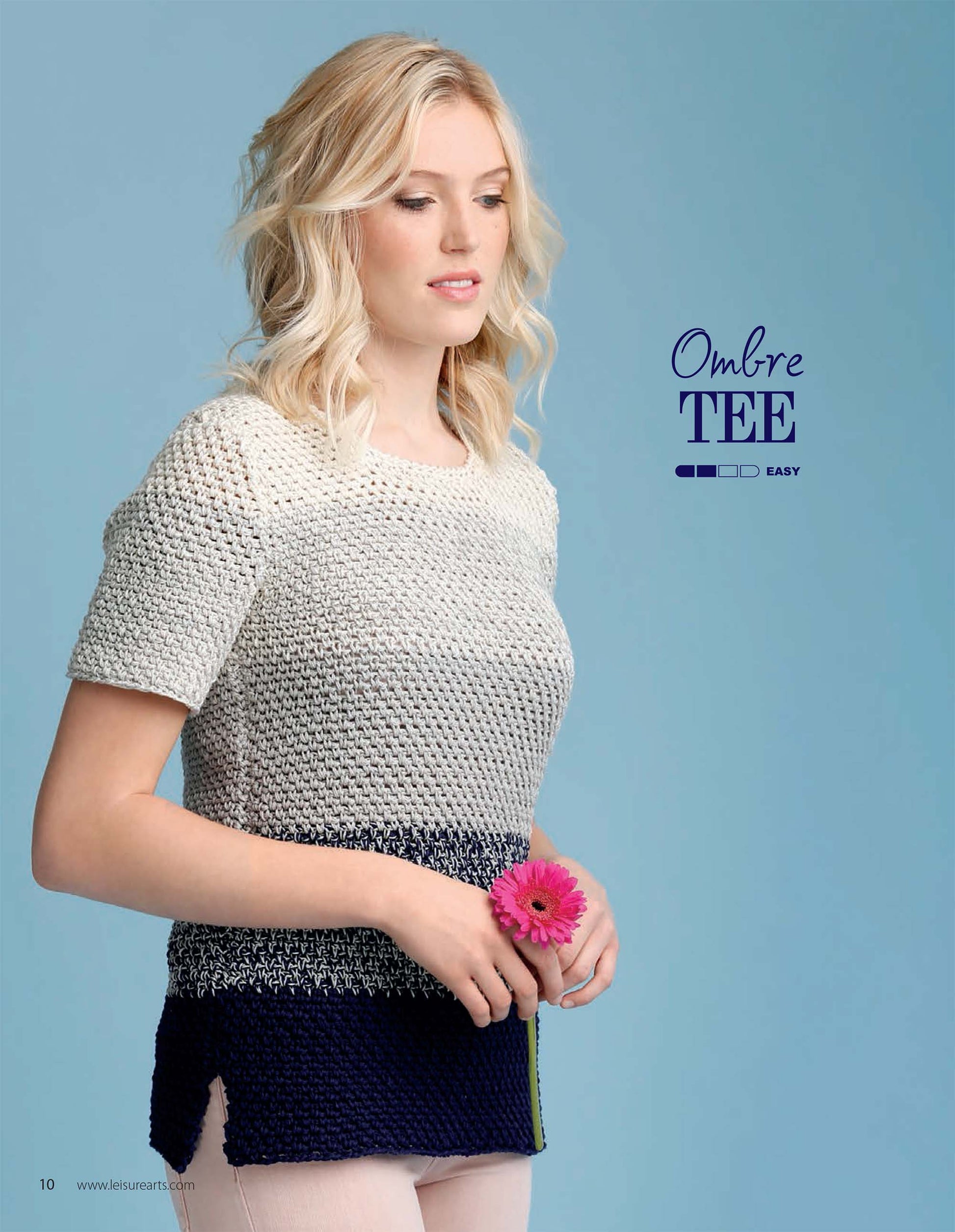 A woman with wavy blonde hair models a short-sleeved ombre knit tee in white, gray, and navy, holding a pink flower on a blue background. Text: “Crochet Super Simple Summer Tops” by Leisure Arts.