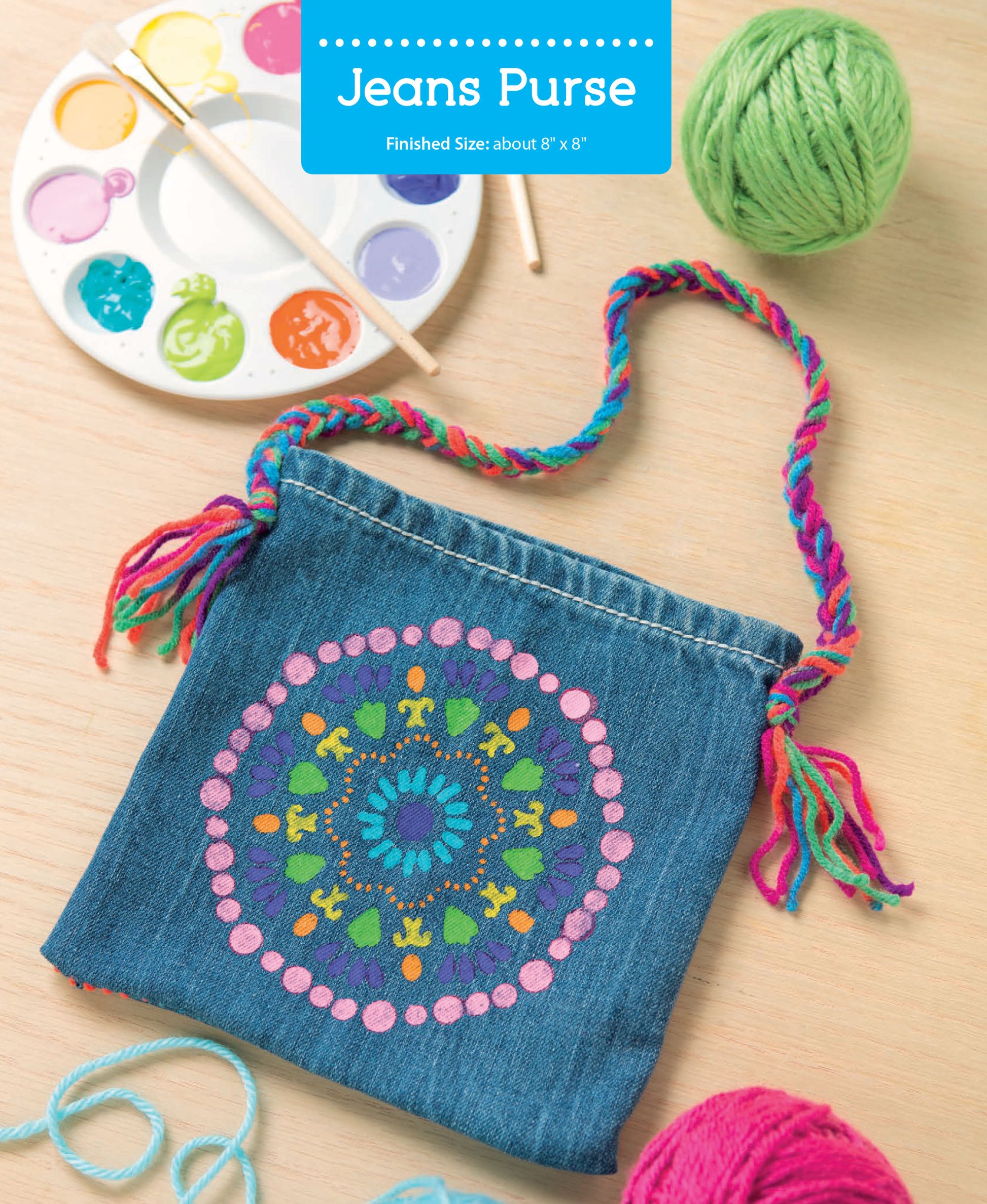 The After-School Kids' Crafts kit by Leisure Arts features a small denim purse with a colorful mandala design in pink, green, blue, and yellow paint. A braided multicolored strap, yarn, and painting supplies are included for a fun beginner project.