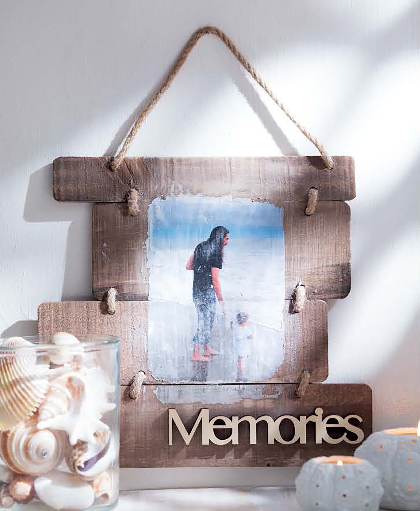 The "Do-It-Yourself Pallet Projects" by Leisure Arts showcases a wooden hanging frame made from shipping pallets, displaying "Memories," with a photo of a woman and child on the beach, plus seashells and candles nearby.