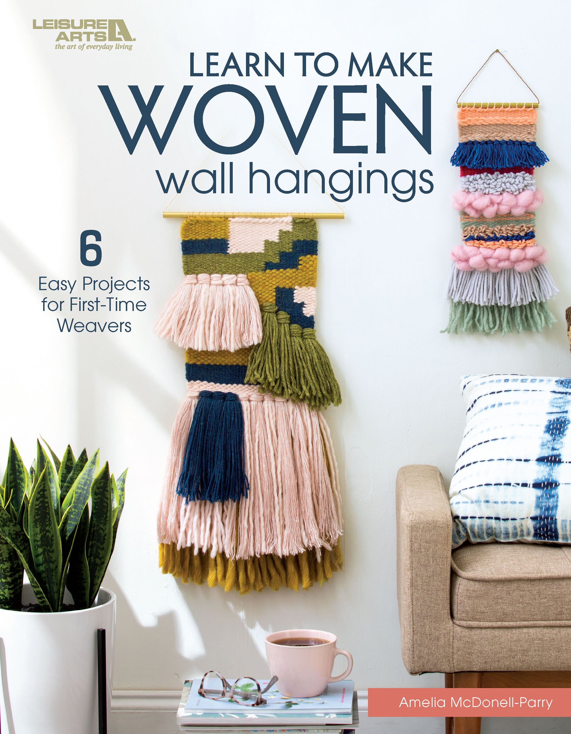 The book cover for Learn to Make Woven Wall Hangings by Leisure Arts shows vibrant frame loom projects on a white wall, with a plant, pink mug, and beige sofa. Text highlights 6 beginner tapestry patterns perfect for new weavers.