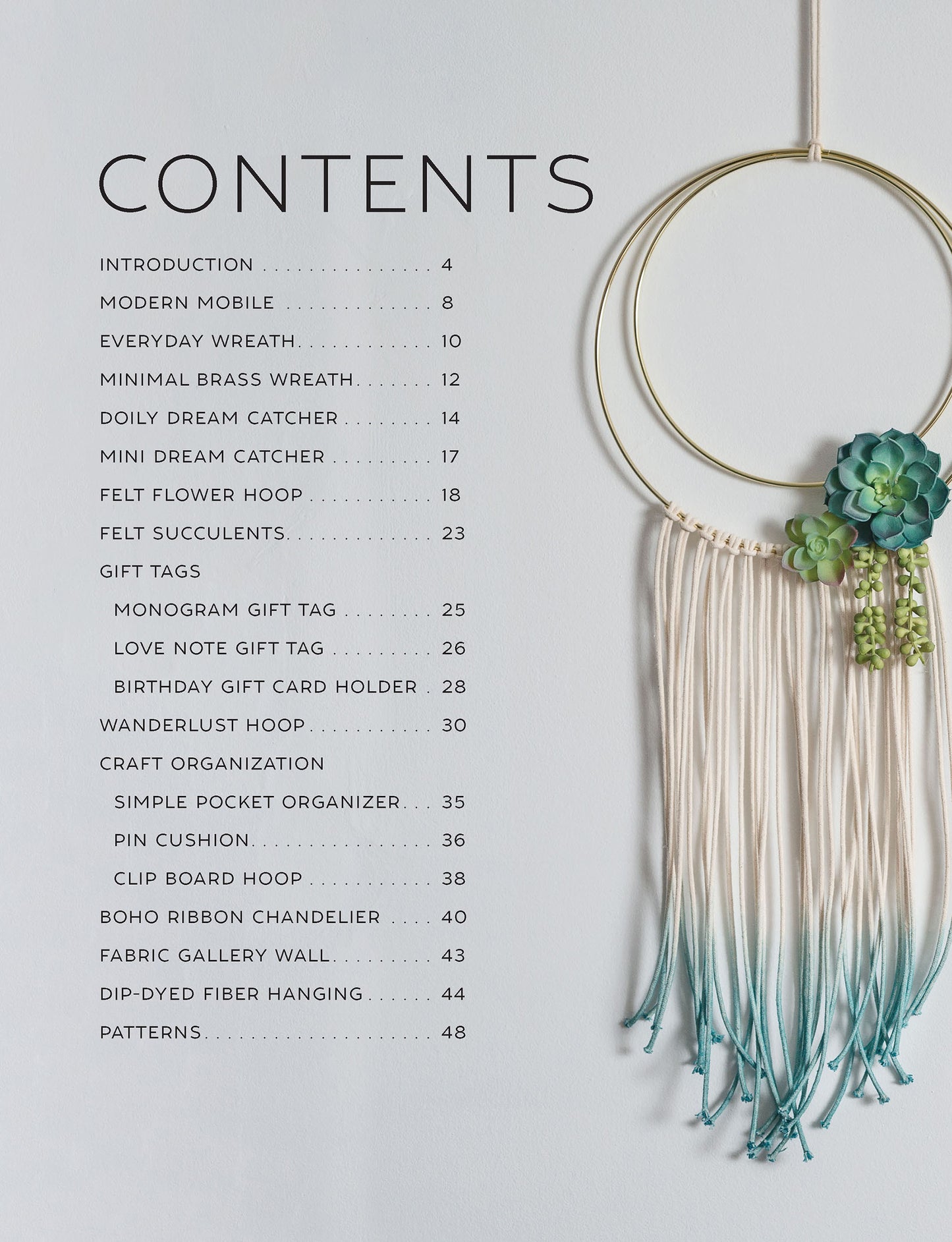 A table of contents sits beside the Leisure Arts Hoops Hooray! Digital Download, featuring a decorative wall hanging made with brass rings, ombre-dyed white and teal strings, and faux succulents for a dreamy, modern touch.