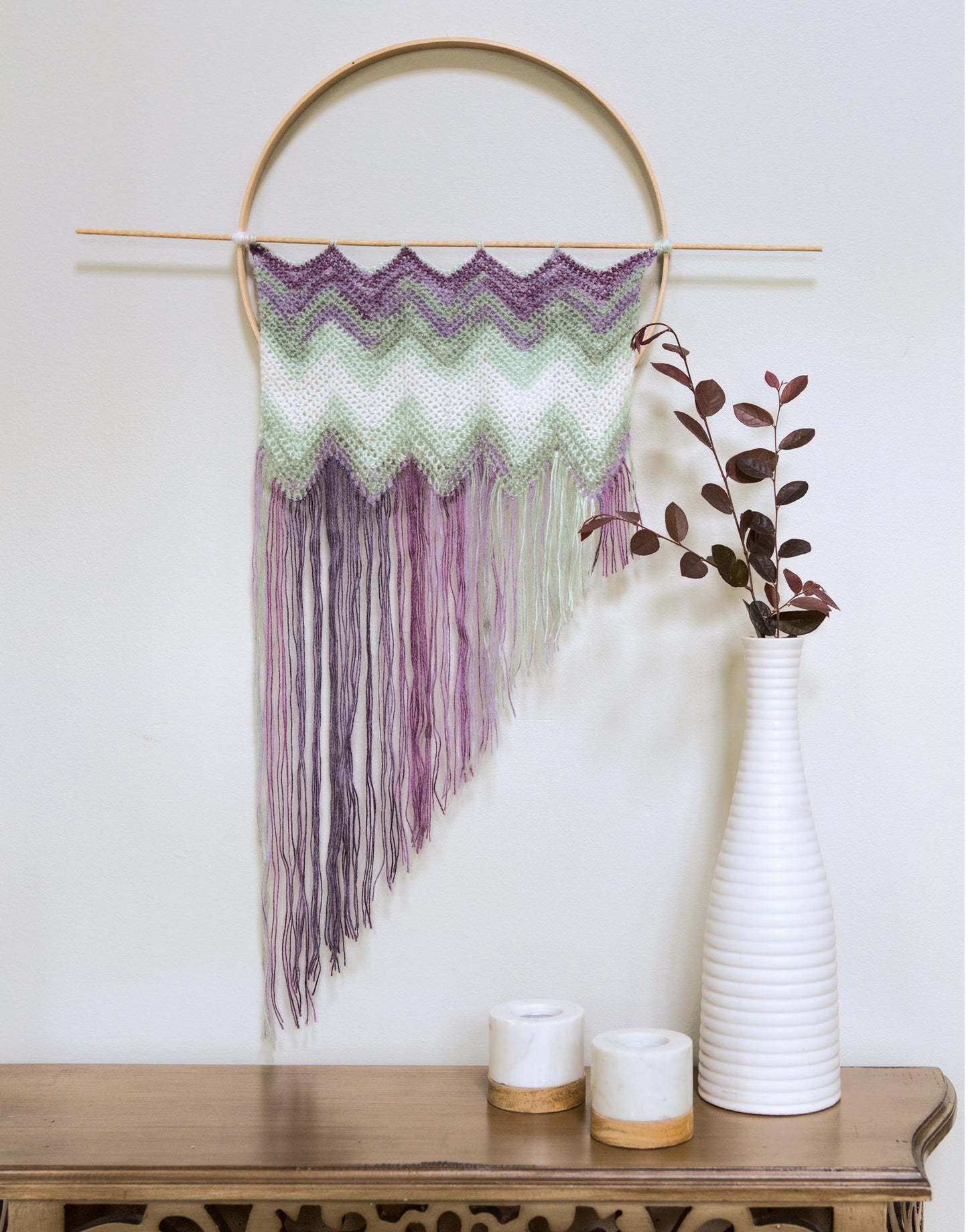 Add boho style to your home with Leisure Arts' "Wall Hangings—8 Stylish Projects to Define Your Space!" digital download, featuring chevron crochet patterns in purple and mint, perfect for displaying above a console table.