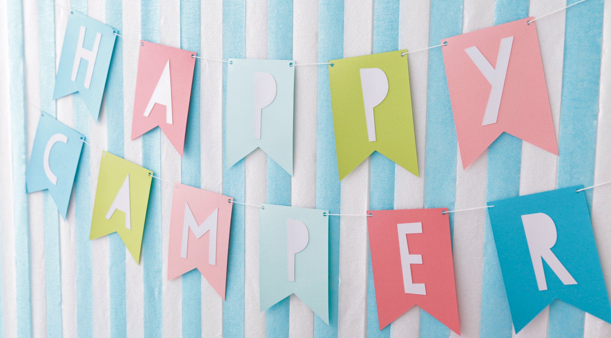 Create festive décor with pastel pink, blue, and green paper flags that spell “HAPPY CAMPER.” From Leisure Arts’ Paper Party—Easy-to-Make Projects for Parties, Celebrations & Even Home Decor. Perfect for parties or crafting fun!.