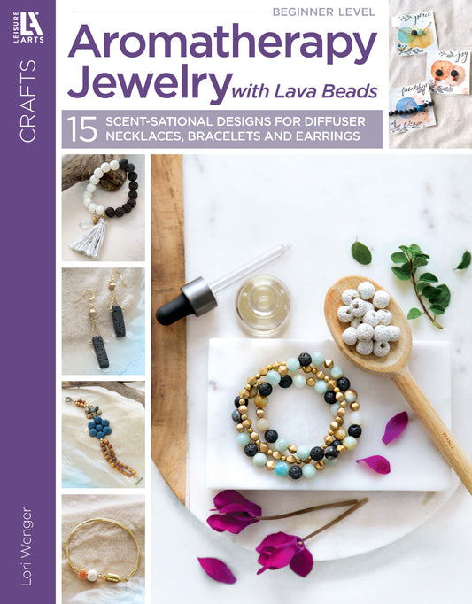 Cover of Leisure Arts’ "Aromatherapy Jewelry with Lava Beads" shows essential oil jewelry, lava beads, a dropper bottle, and pink flower petals on a white background, emphasizing jewelry making techniques.