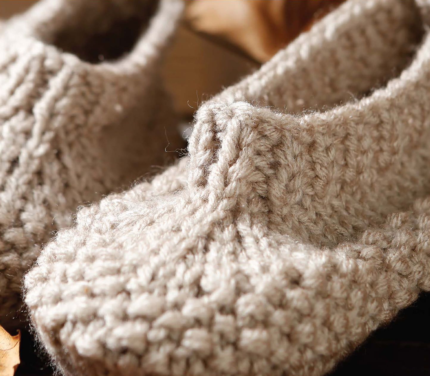 Close-up of cozy, hand-knitted beige slippers with a chunky texture—perfect inspiration for easy projects from Everyday Men's Knits by Leisure Arts, ideal for anyone interested in men's knitting patterns.