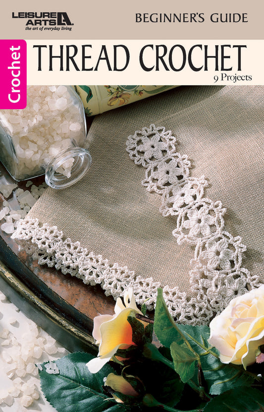 Leisure Arts’ Thread Crochet—A Beginner's Guide to 9 Projects Digital Download features a brown crochet book cover with delicate lace edging, plus a jar of white beads and a yellow flower. Perfect for beginners seeking beautiful results.