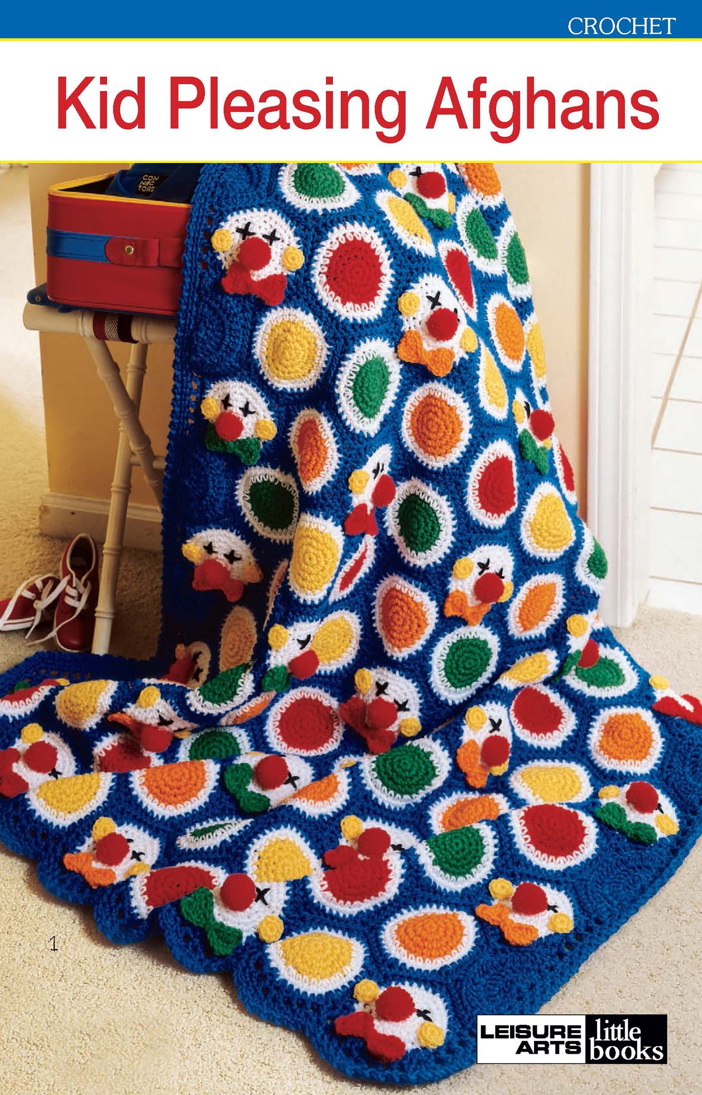 Cover of Kid-Pleasing Afghans by Leisure Arts, featuring a blue crocheted afghan with clown faces and colorful circles in red, yellow, green, and orange motifs.