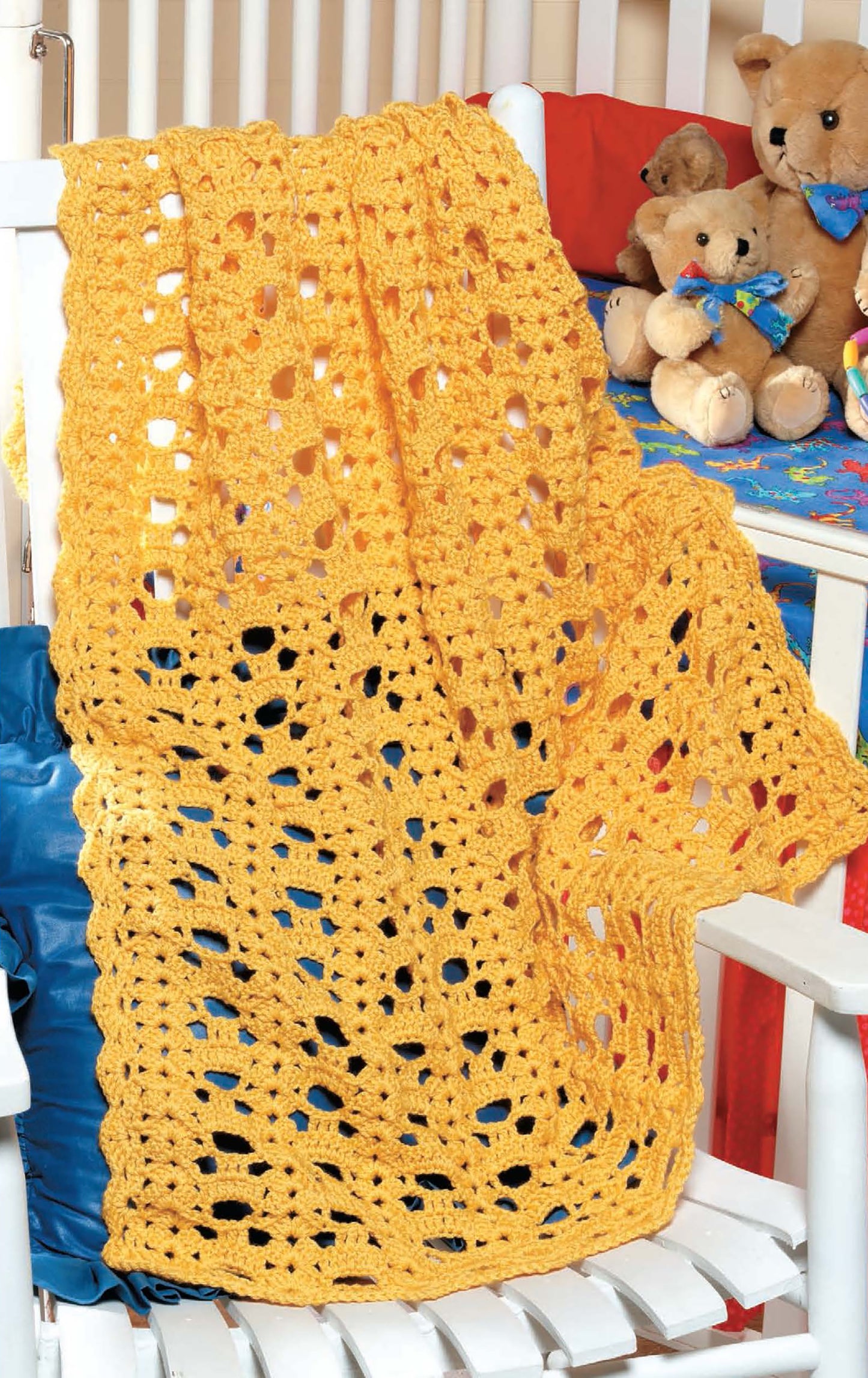 The Kid-Pleasing Afghans by Leisure Arts features a yellow afghan stitch blanket draped over a white wooden chair, with blue and red pillows and teddy bears in the background.