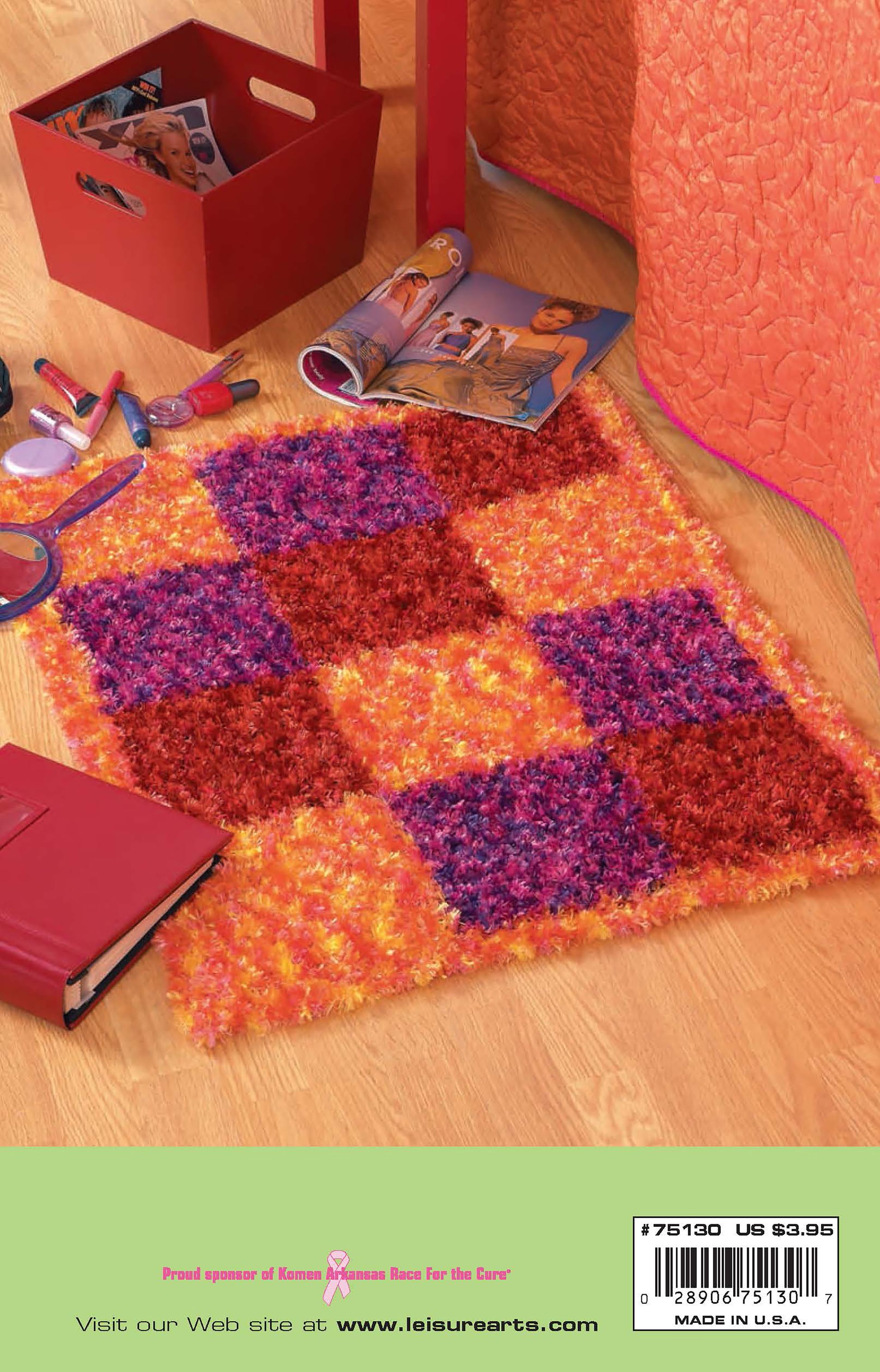 A fluffy, checkered rug in orange, purple, and red—ideal for cozy decor from Leisure Arts' "Knits for the Home"—rests on a wooden floor near a red craft box, binder, nail polish, makeup, and an open magazine with a woman.