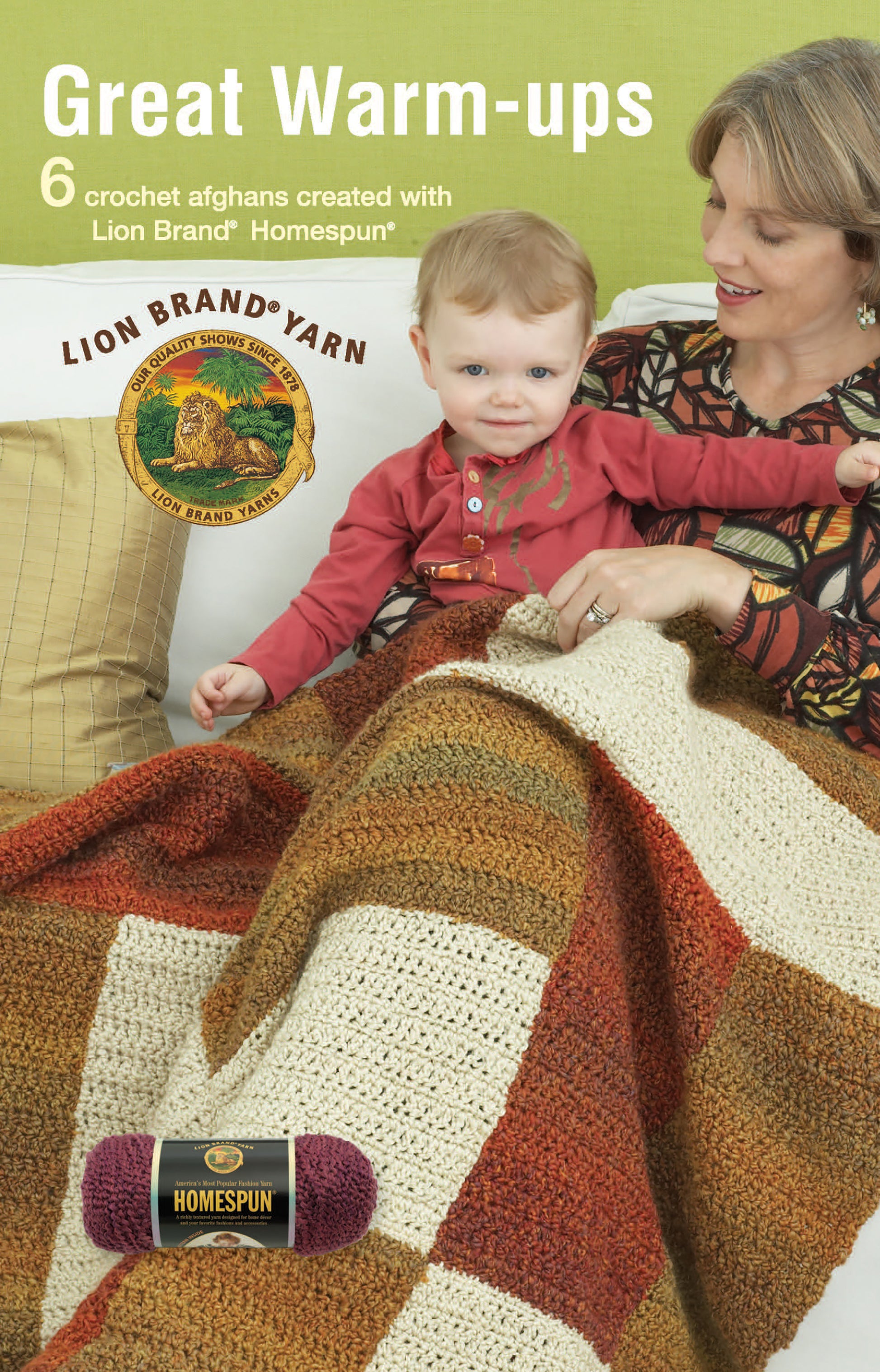 A woman and child sit on a couch with a large, brown-and-cream crochet throw from "Great Warm-Ups" by Leisure Arts.