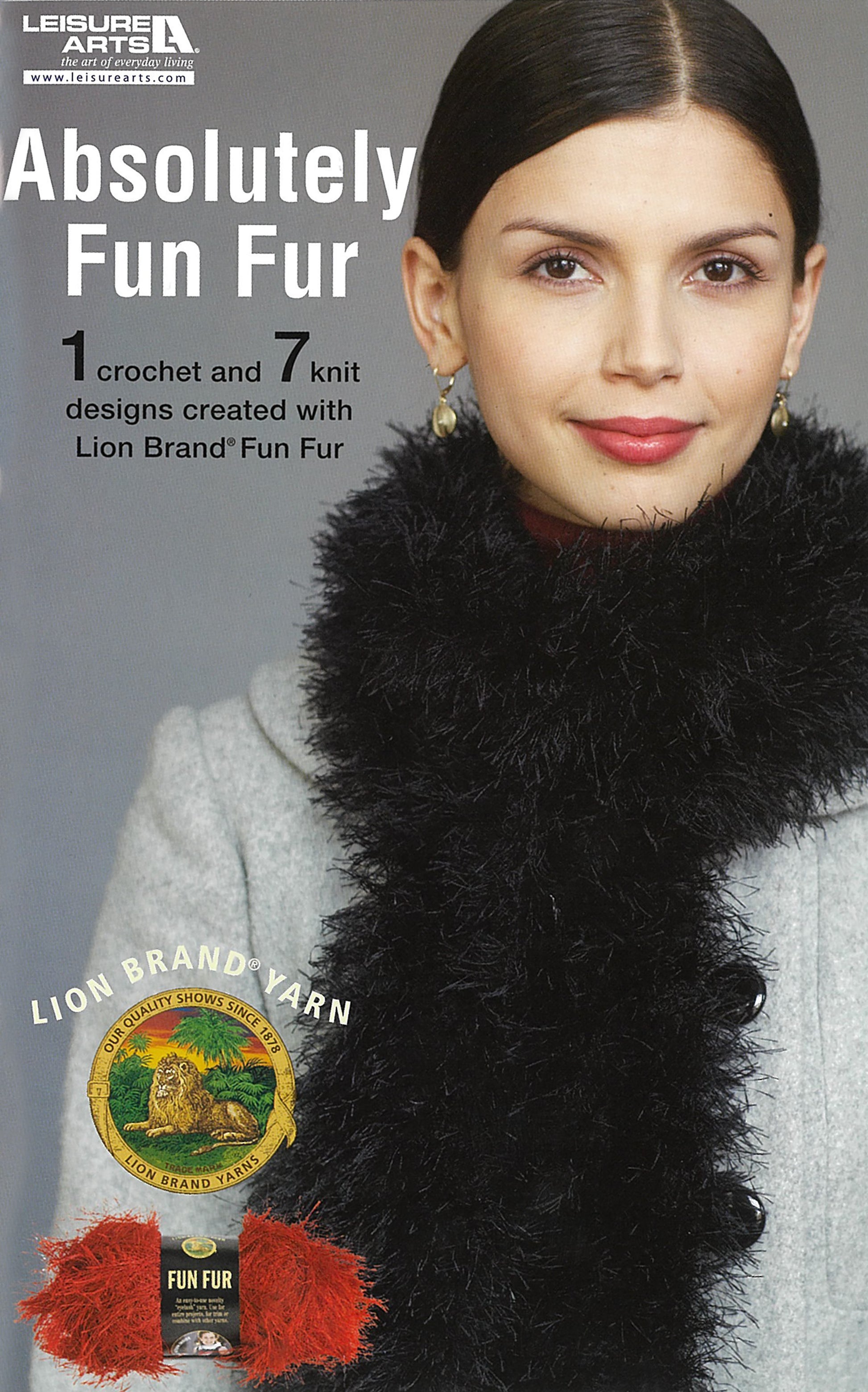 A woman in a light gray sweater and thick black fur-yarn scarf smiles. Text: Leisure Arts’ Lion Brand Yarn's Absolutely Fun Fur Digital Download—1 crochet & 7 knit designs. Lion Brand Yarn logo shown.