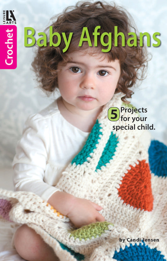 A baby with curly brown hair holds a colorful crocheted blanket. The cover reads: Baby Afghans—Cuddly Wraps for Babies & Toddlers! by Leisure Arts, featuring easy crochet patterns for beginners.